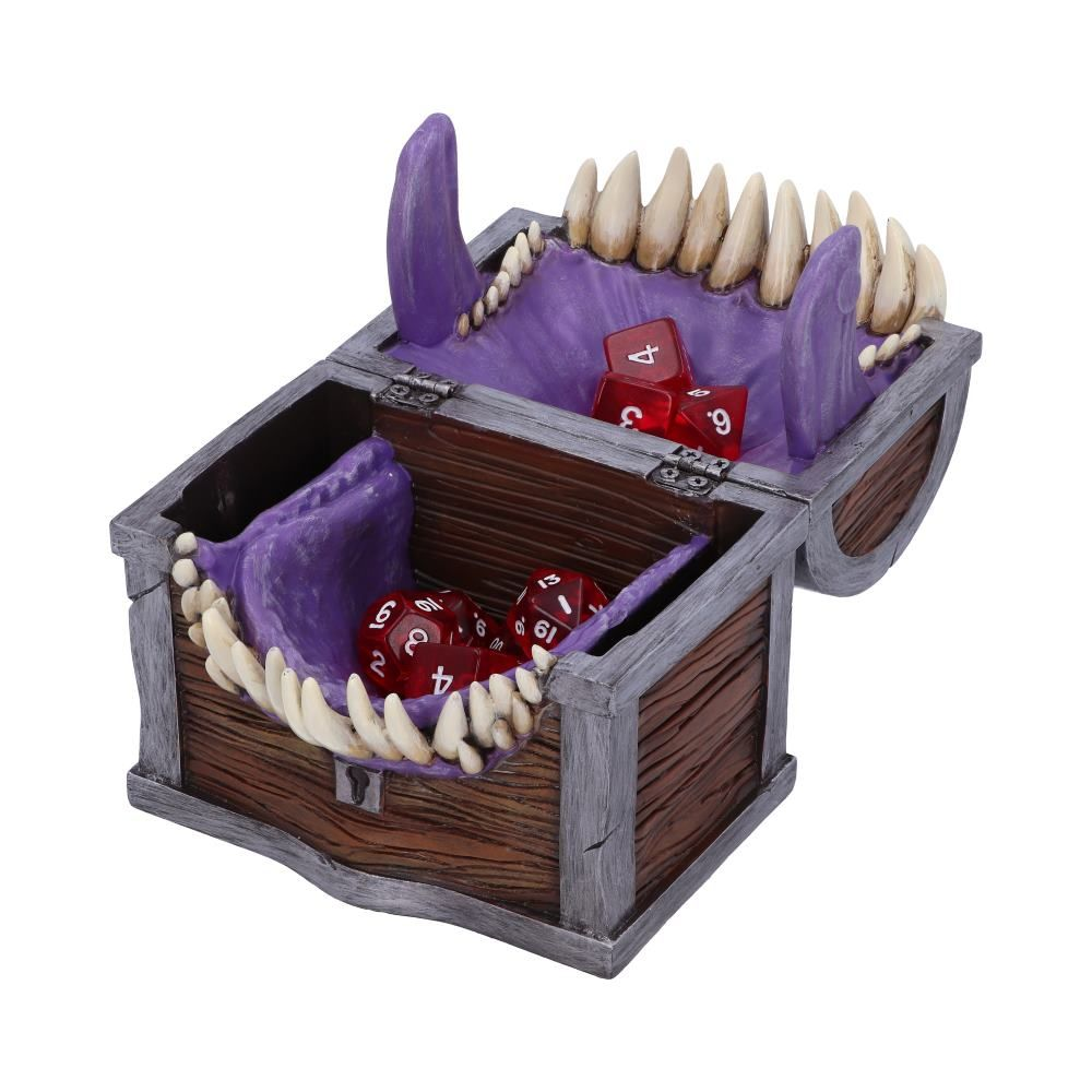 Een houten kist met rode dobbelstenen erin. De kist heeft tanden en een paars interieur. Het ziet eruit als een monster.