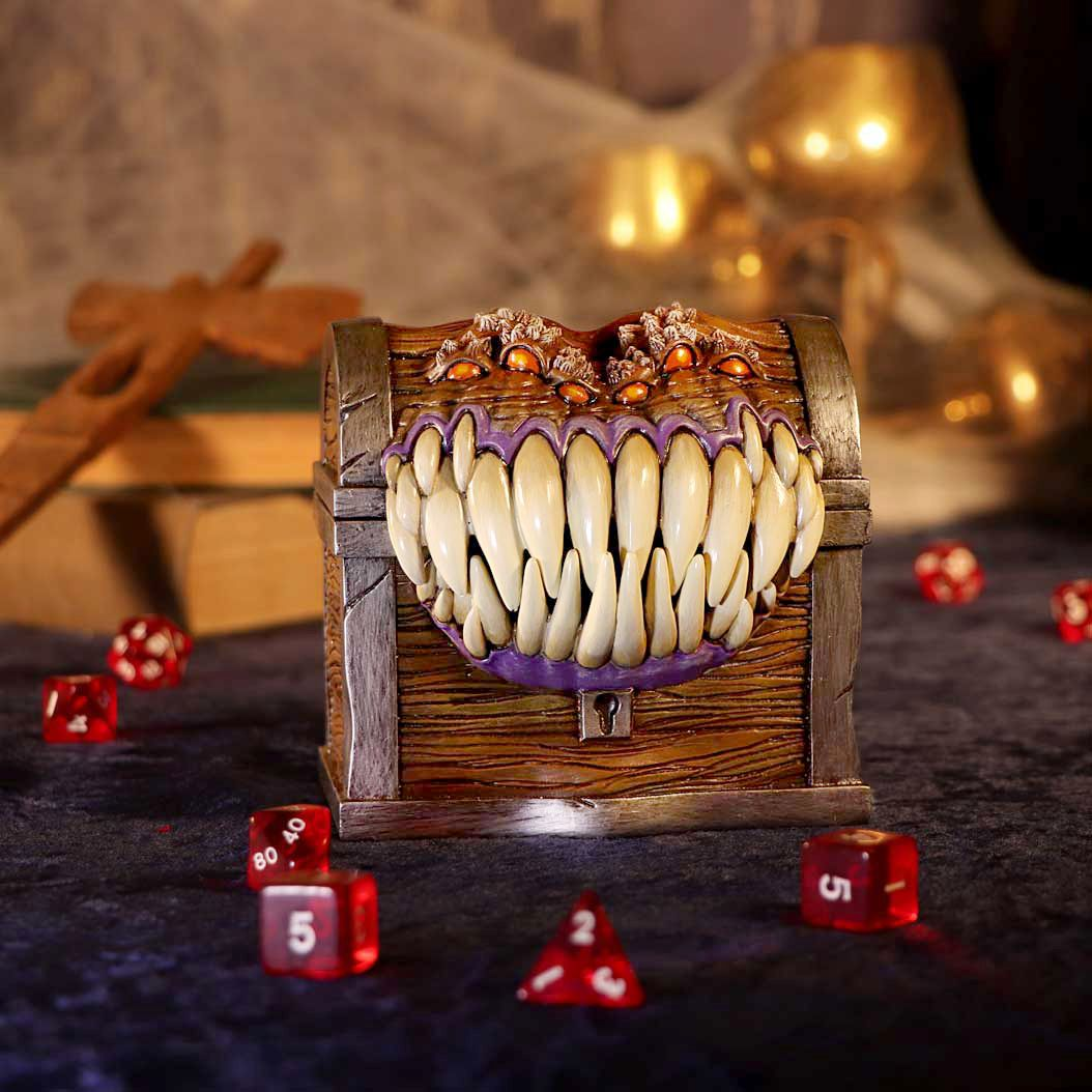 Een houten kist met een monstergezicht. Het monster heeft veel tanden, ogen en is bruin.