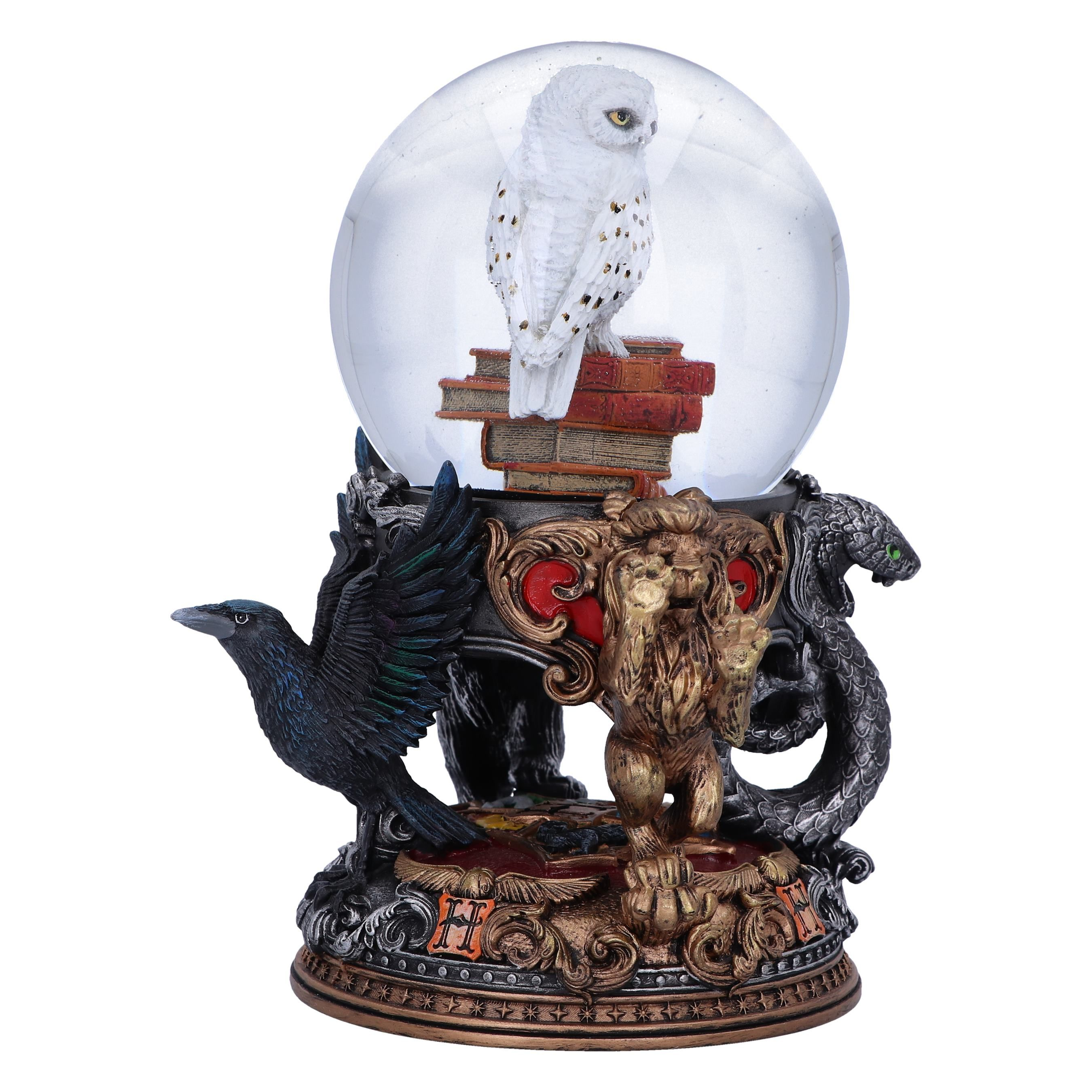 Snow globe featuring a white owl on books, with a raven, a lion, and a snake, all on a detailed base.