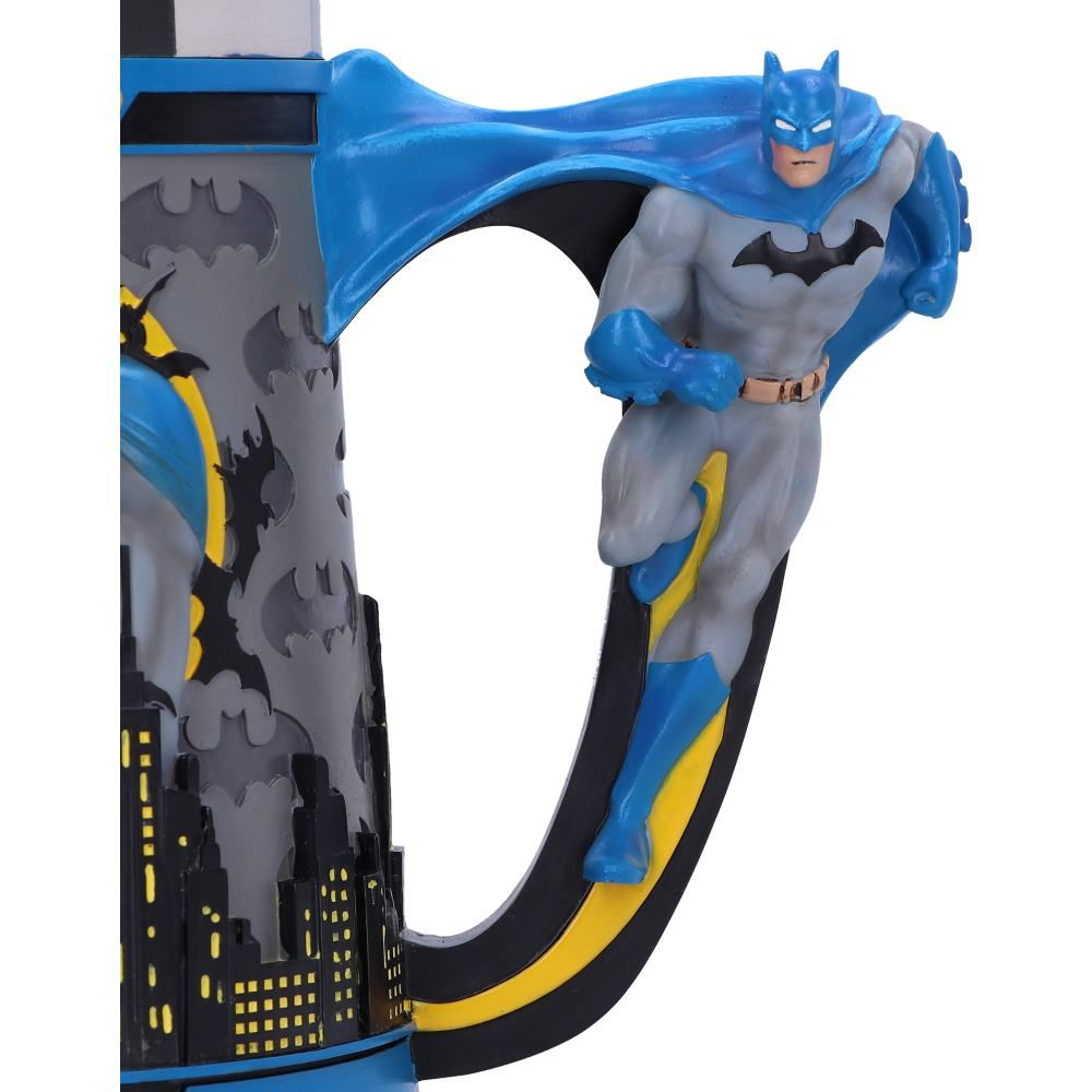 A Batman mug with a Batman figure on the handle, and a city silhouette on the side, against a white background.