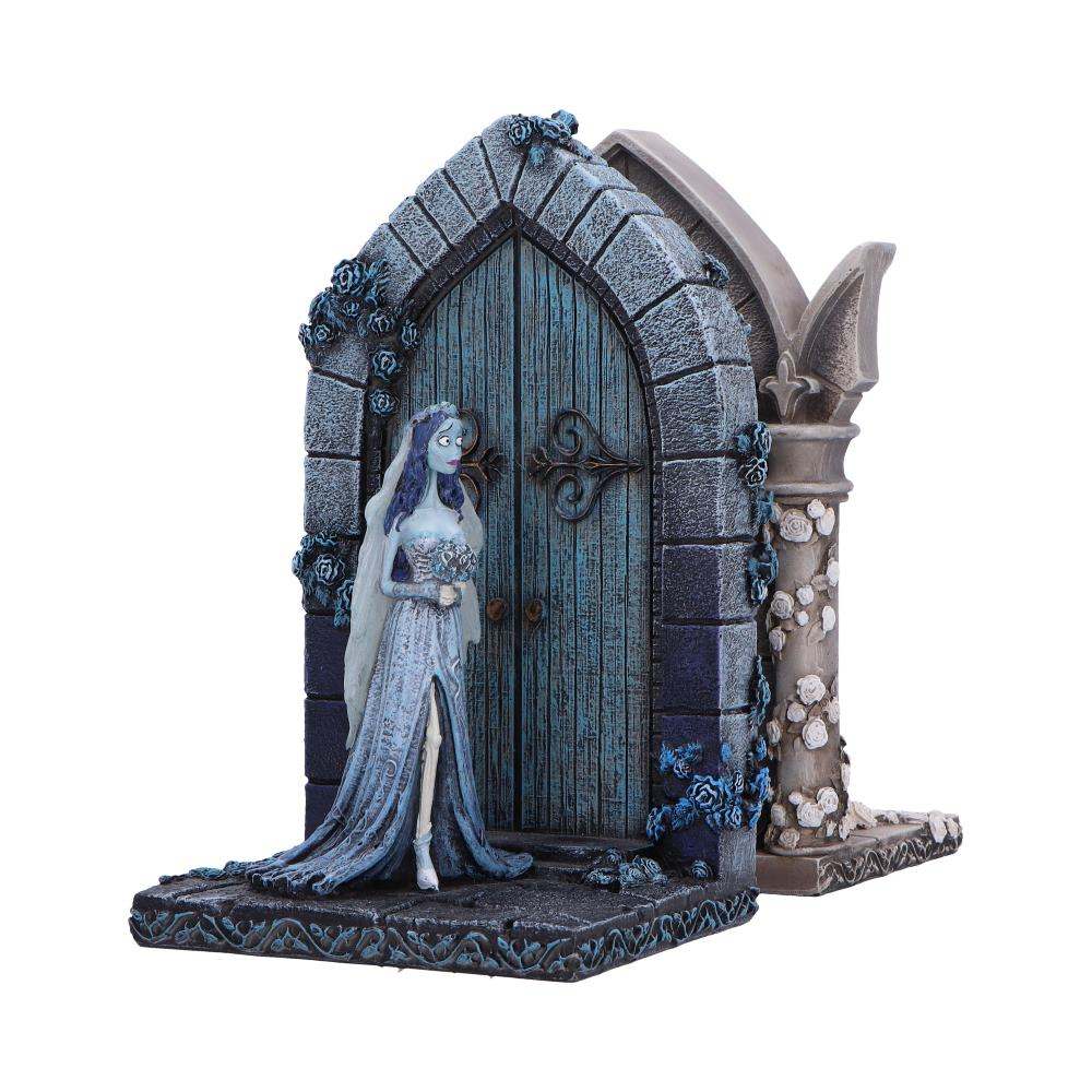 Corpse Bride boekensteun. Een figuur staat bij een blauwe deur. Stenen boog en rozen maken de scène af.