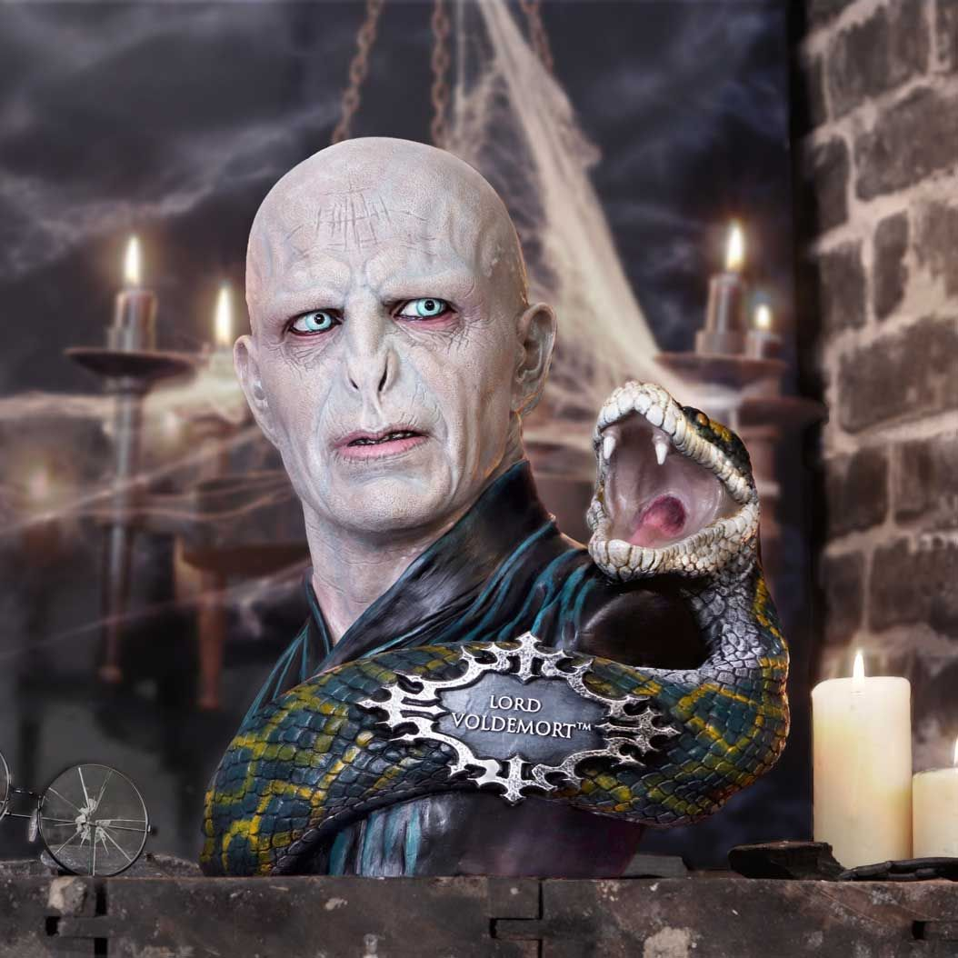 Lord Voldemort buste met een slang om zijn arm, kaarsen en een bakstenen achtergrond.