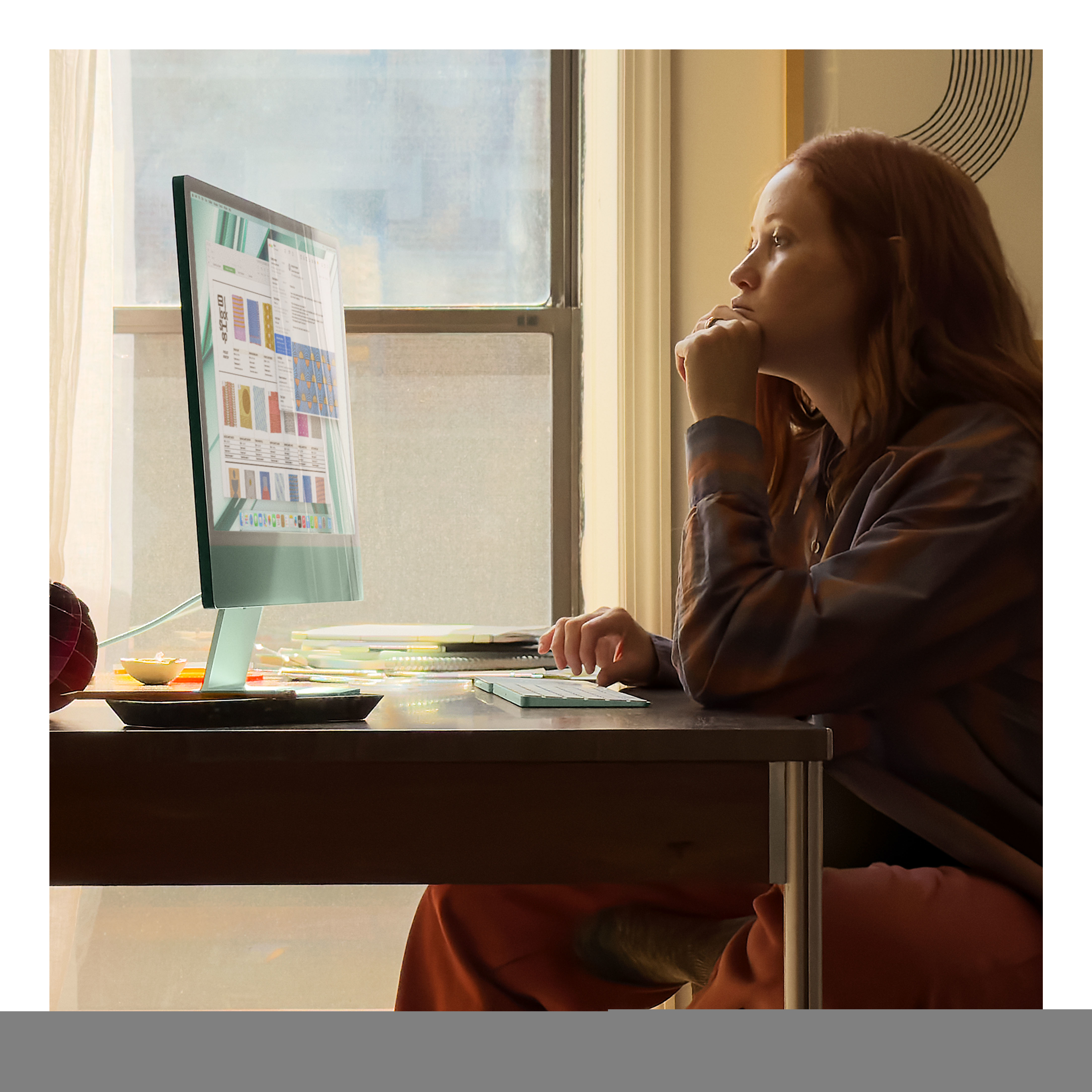 Kobieta z rudymi włosami patrząca na ekran komputera z kolorowym wykresem.