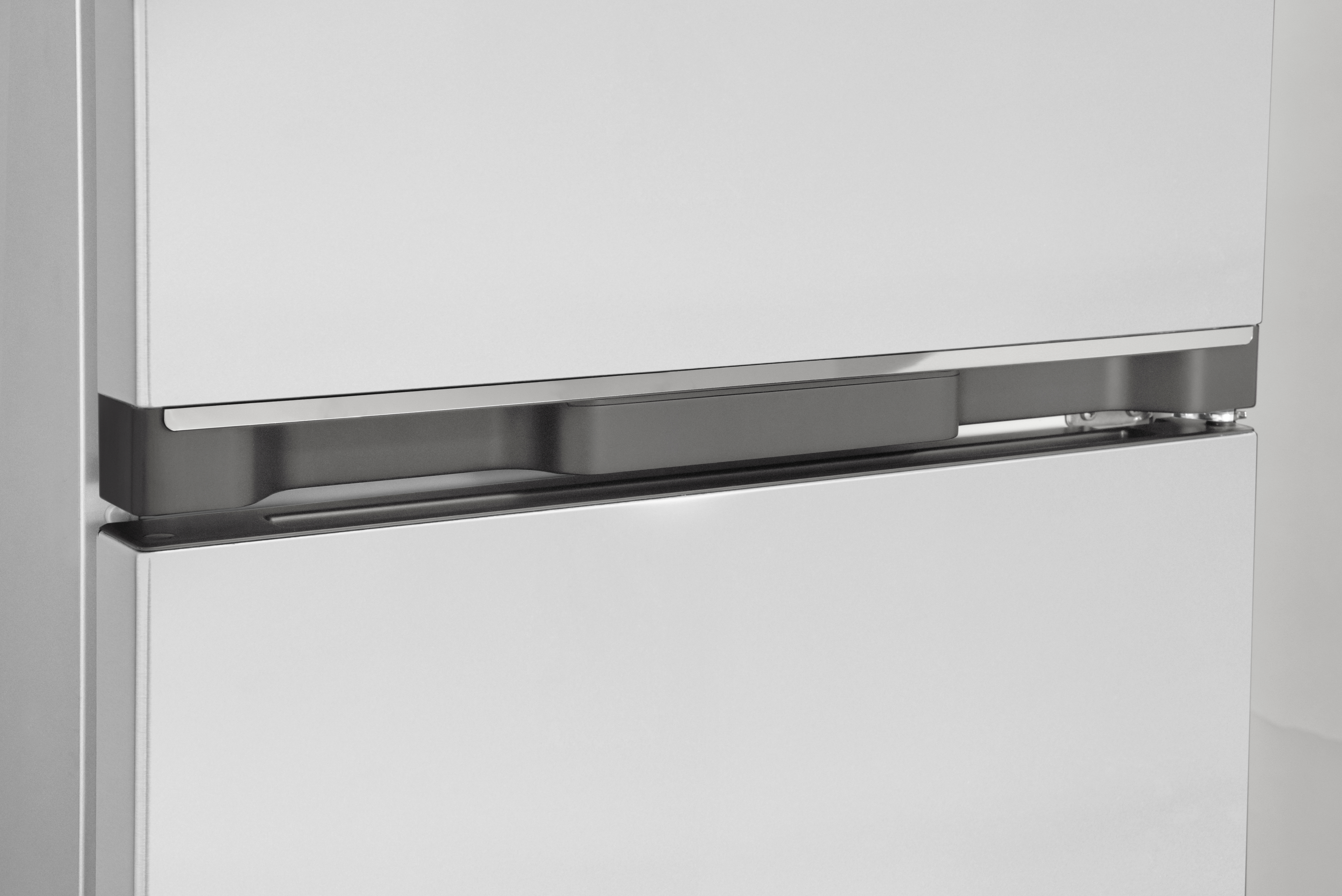 Close-up of a white refrigerator, with a dark grey handle. The bottom door is visible.