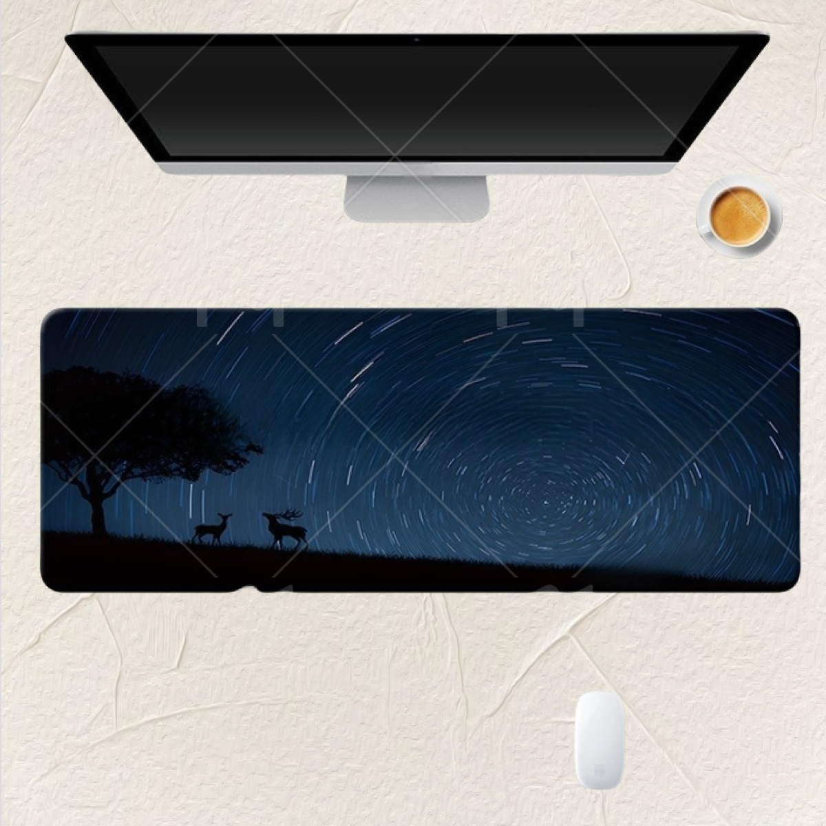 Tappetino per mouse con scena di cielo notturno, albero e sagome di cervi. Computer e tazza di caffè.