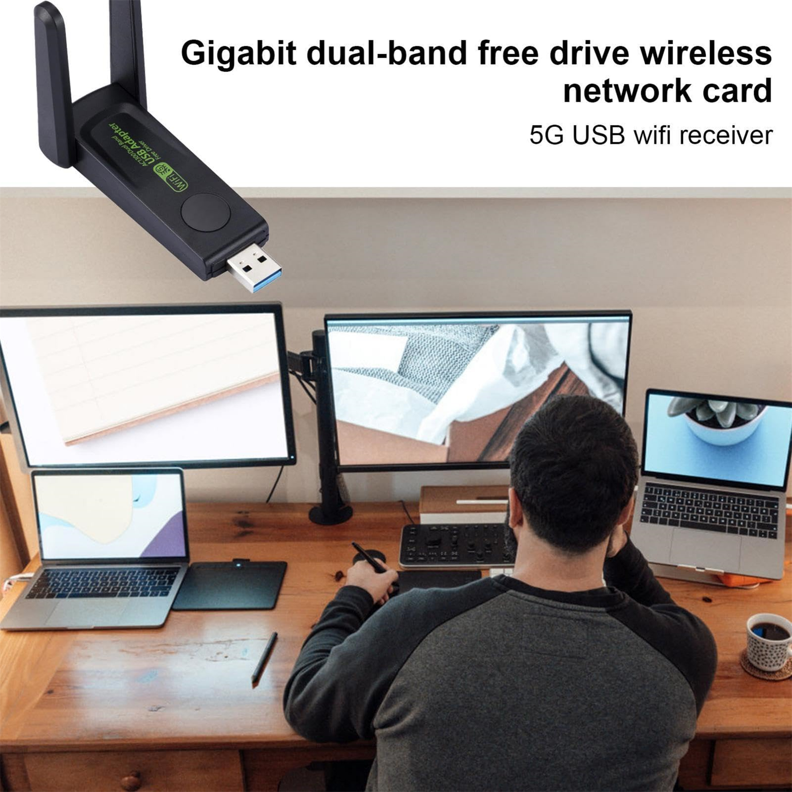 Ein drahtloser USB-WLAN-Adapter neben zwei Monitoren und zwei Laptops, mit einer Person im Hintergrund.