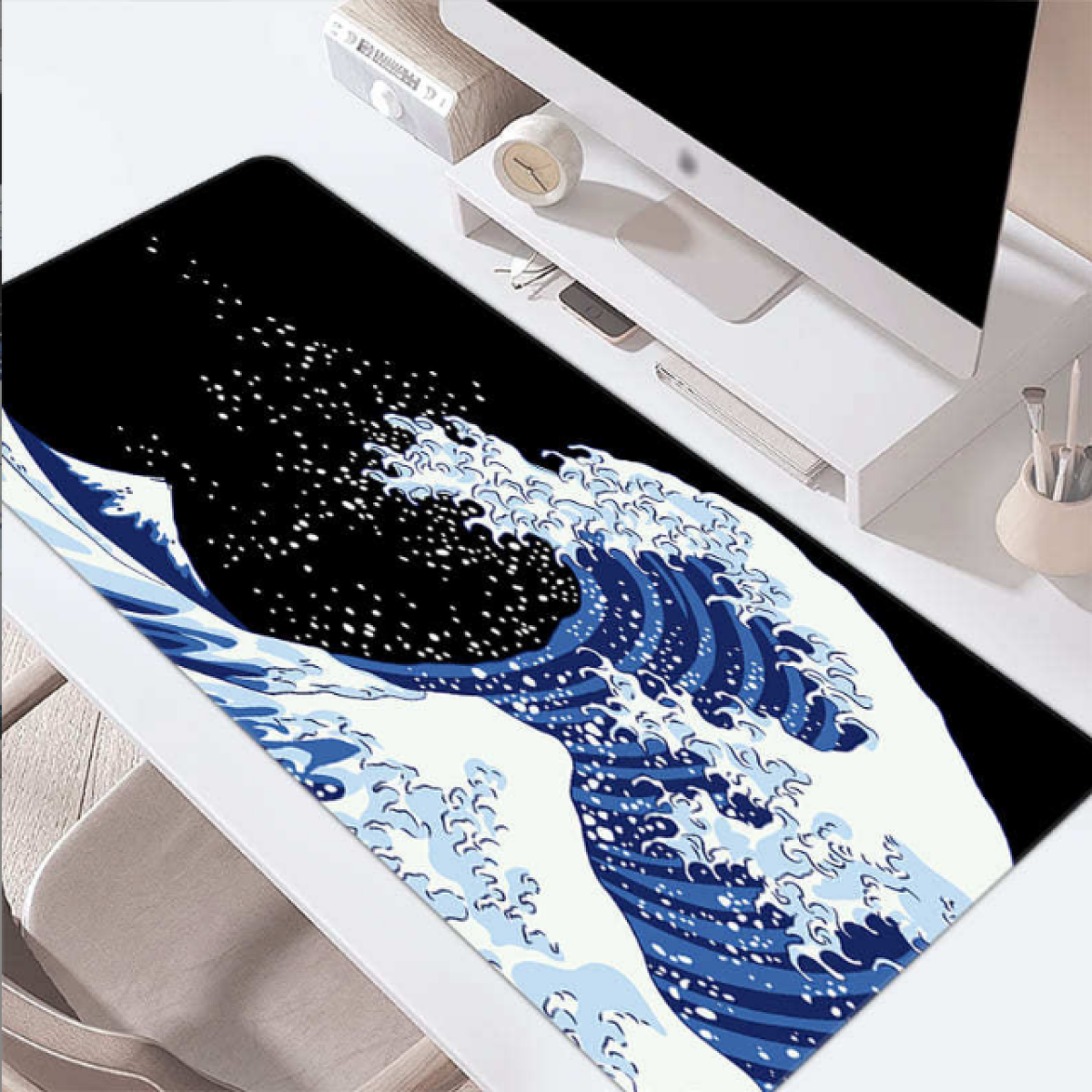 Eine Schreibtischunterlage mit einem blau-weißen Wellendesign. Ein Computer und Zubehör sind sichtbar.