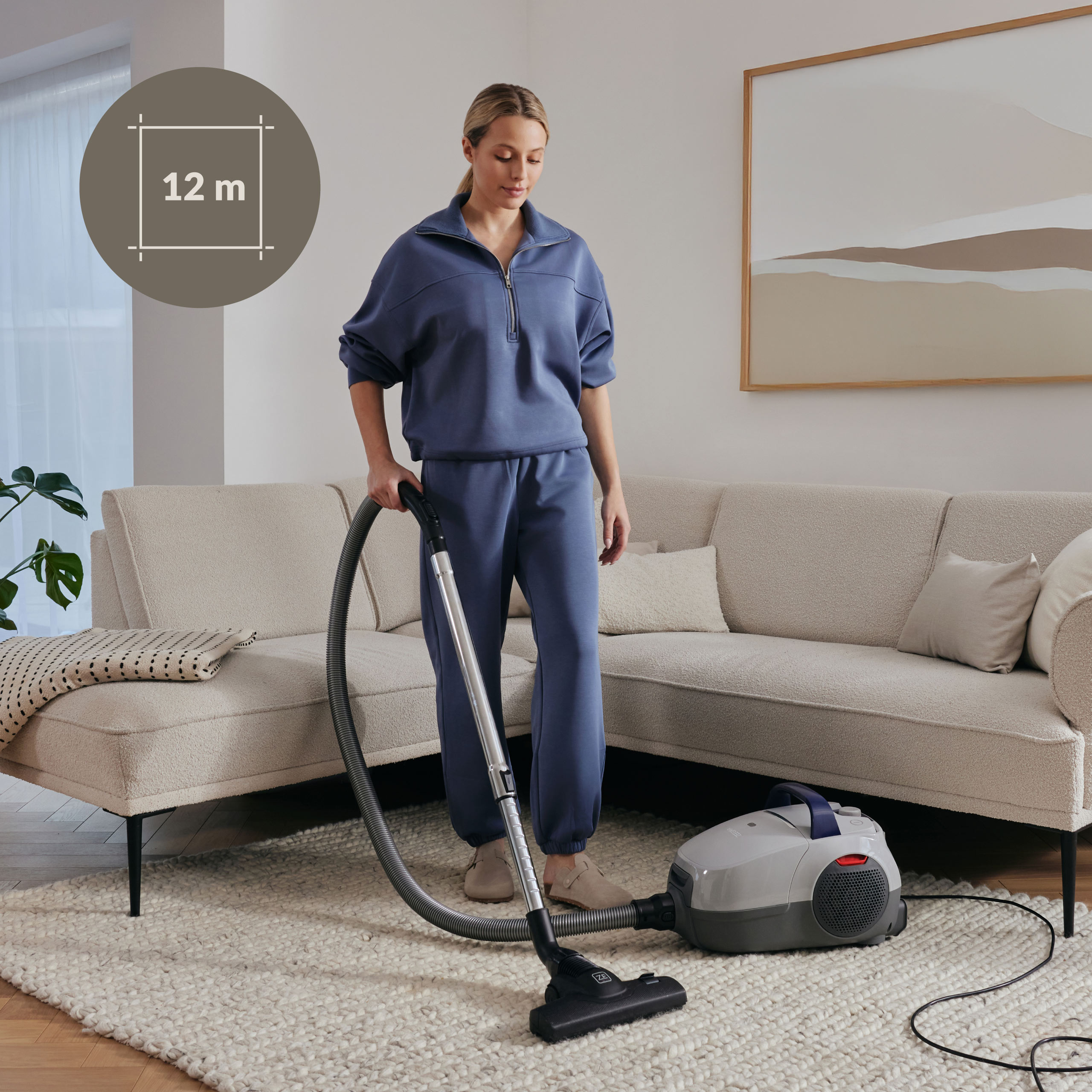 Vrouw die een kamer stofzuigt met een stofzuiger. Inclusief een bank en een kleed.