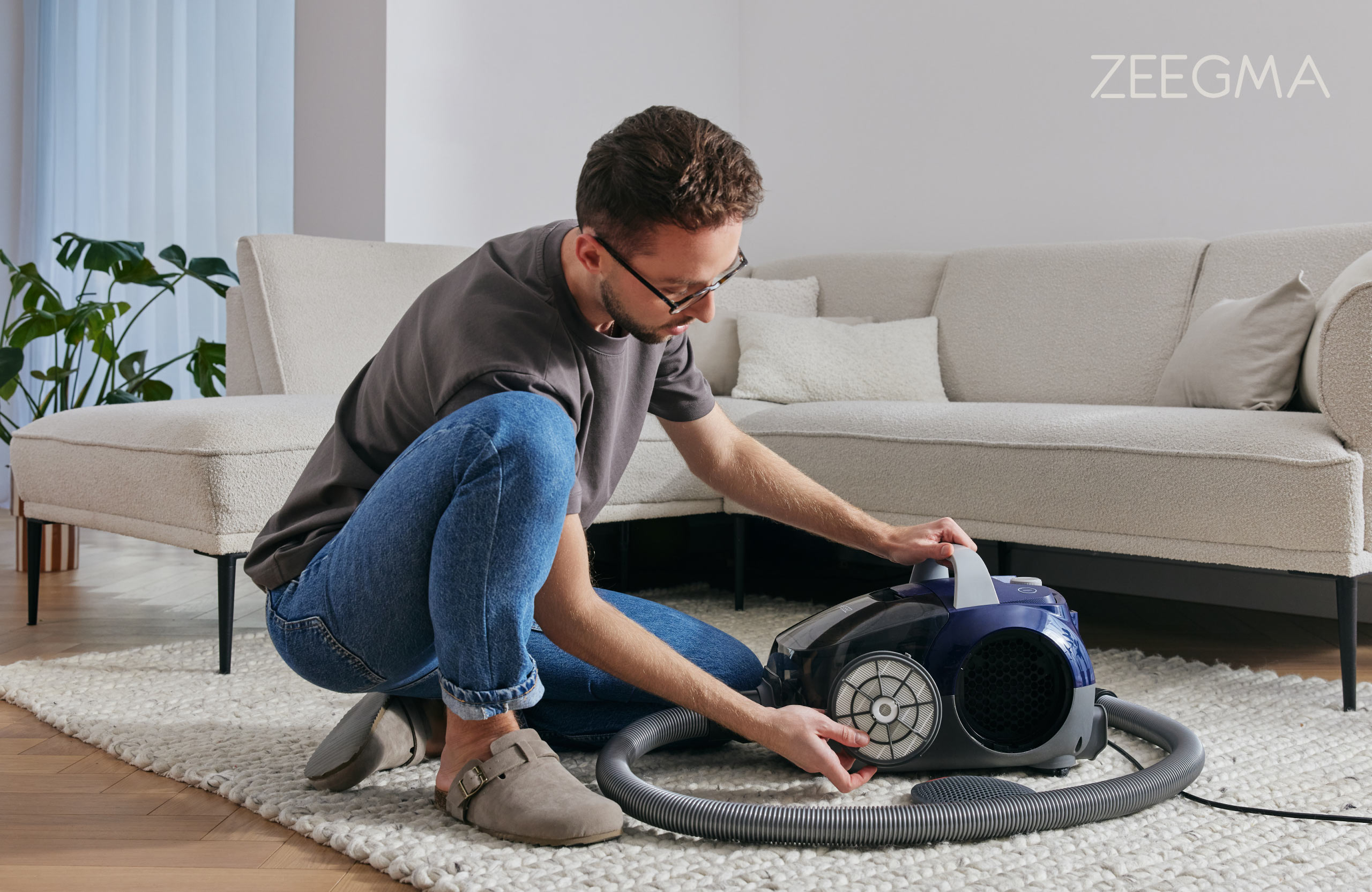 Man die een stofzuiger gebruikt op een tapijt in een woonkamer.