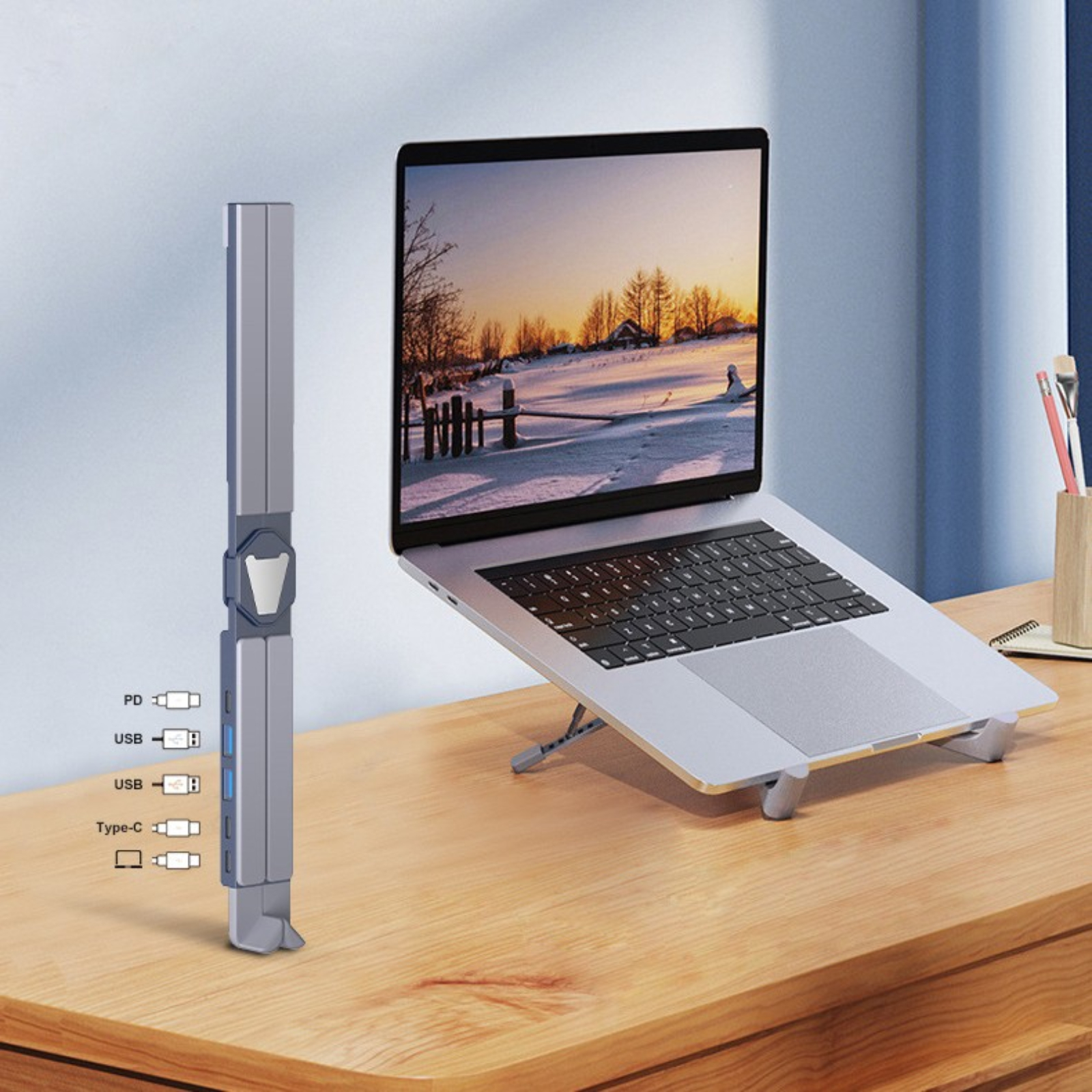 Ein Laptop, der mit einem Ständer aufgestellt ist, und ein Multi-Port-Hub mit Anschlüssen, auf einem Holzschreibtisch.