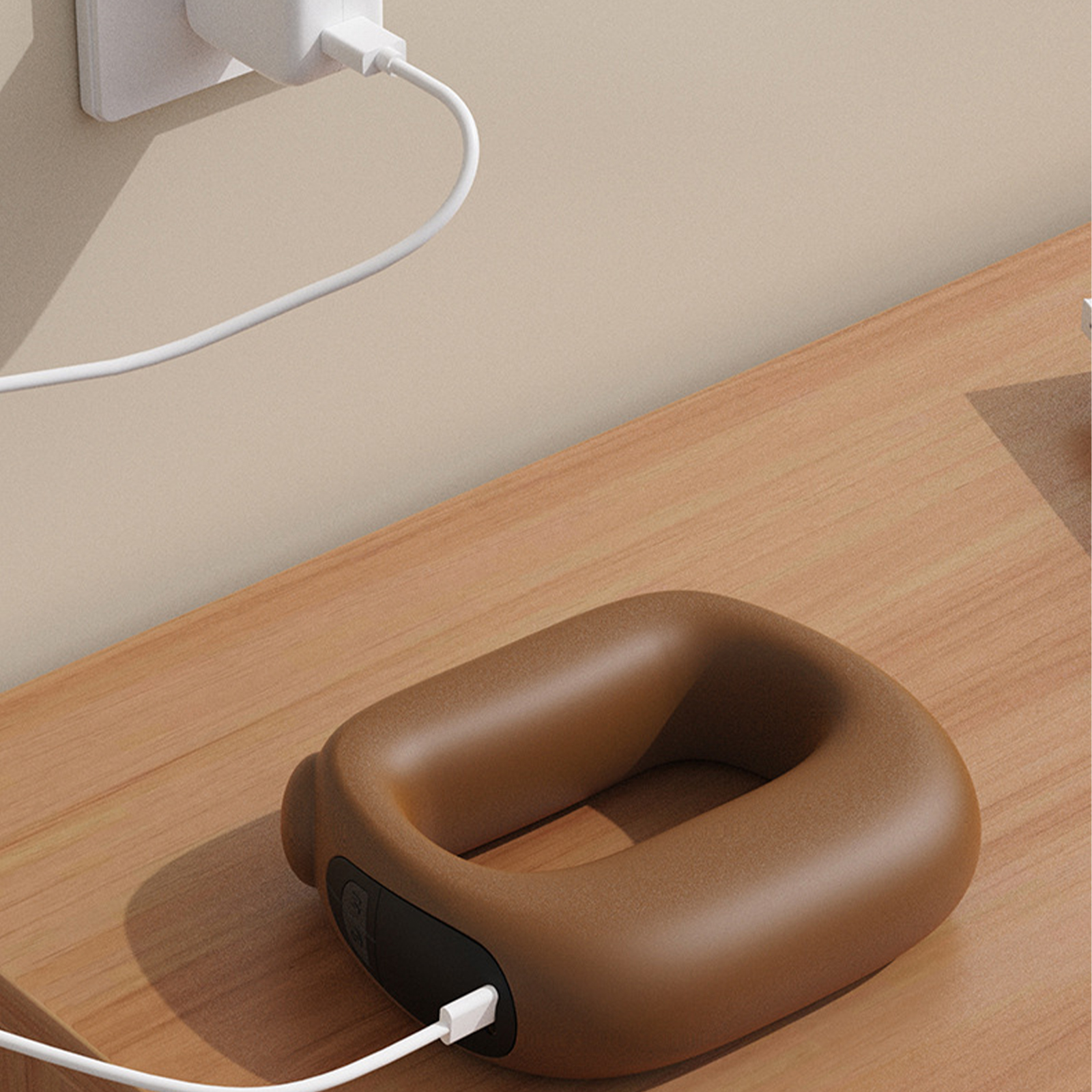 Braunes ringförmiges Gerät, das an eine Steckdose angeschlossen ist, ein Kabel ist daran angeschlossen.