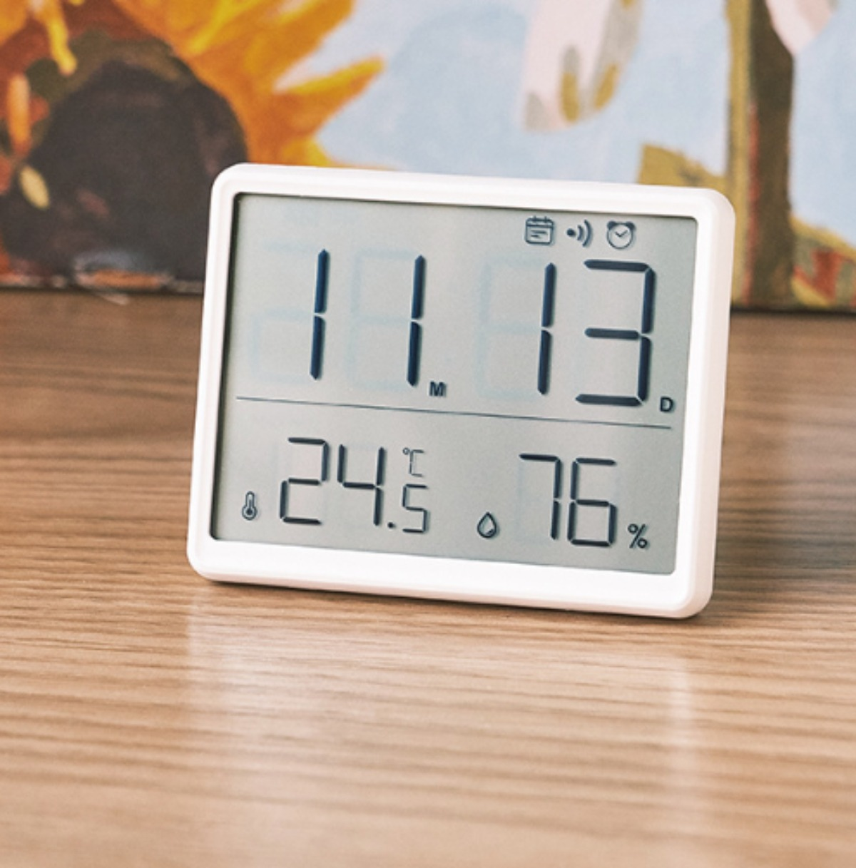 Eine weiße Digitaluhr, die Zeit und Temperatur anzeigt. Sie hat große Zahlen und ein sauberes Design.