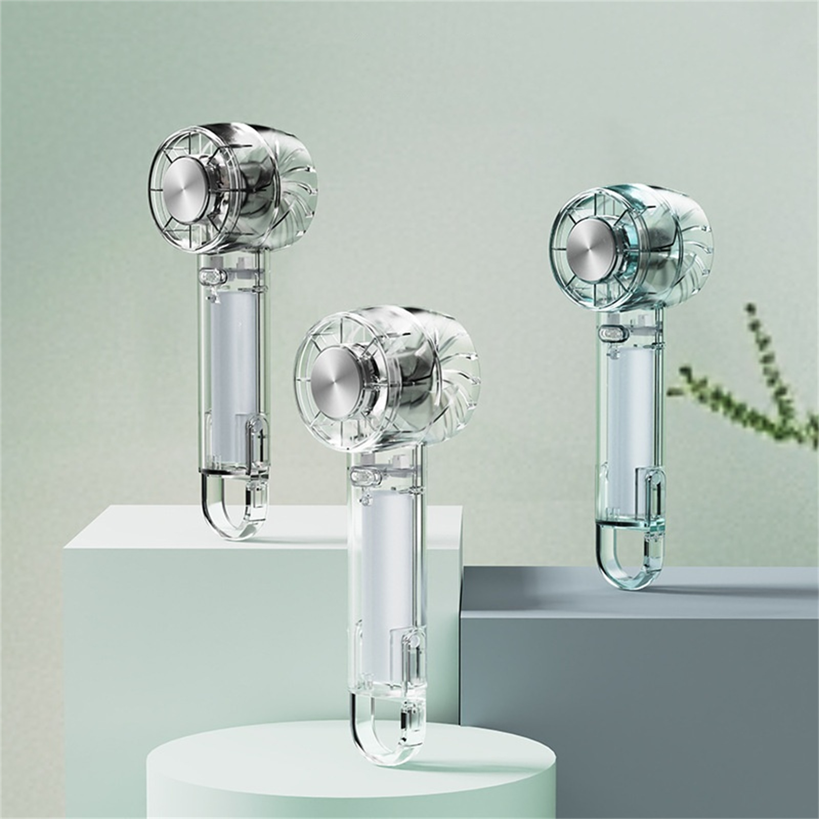 Drei transparente Handventilatoren mit silbernen Oberteilen und klaren Griffen.
