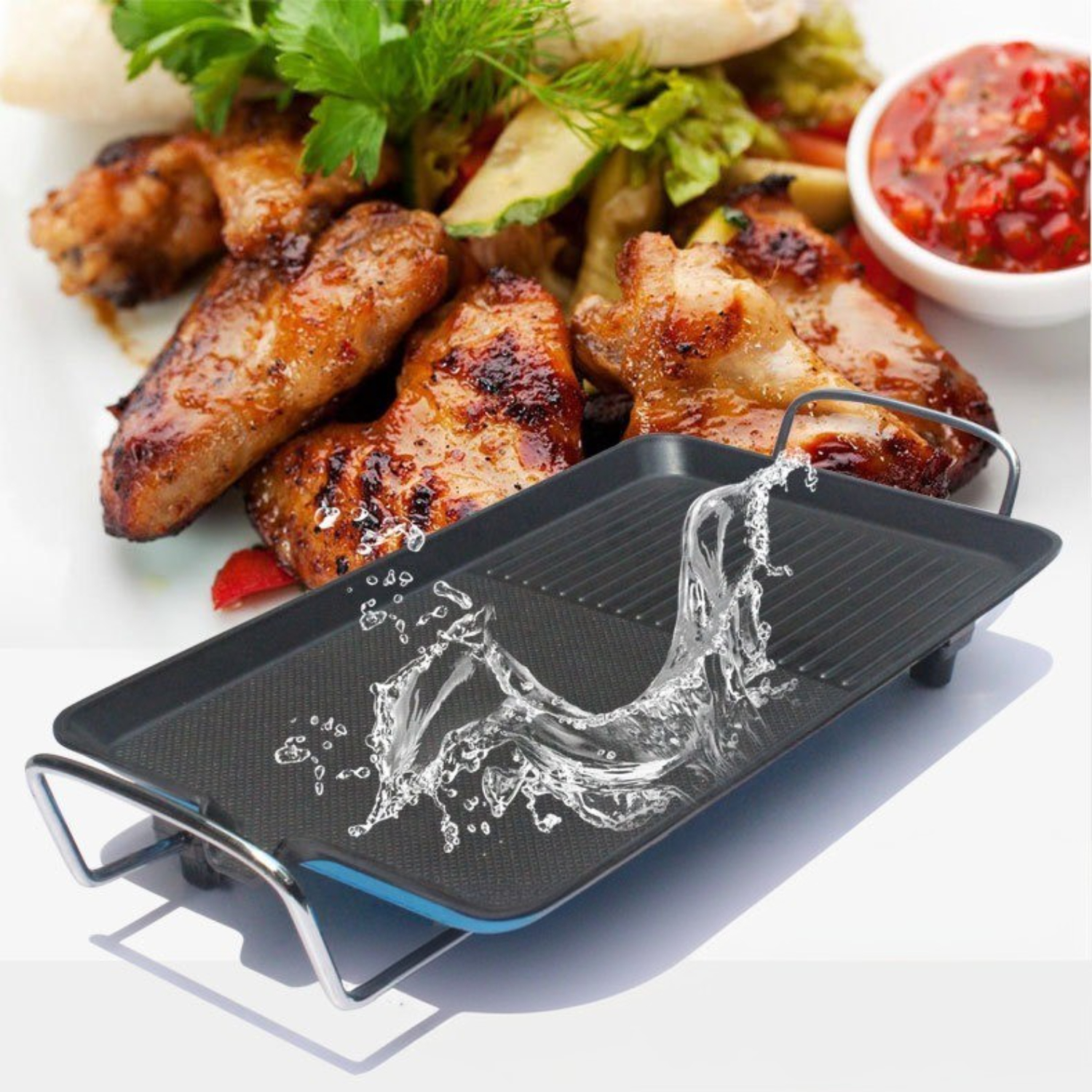 Gegrillte Hähnchenflügel auf einem Teller. Wasser spritzt auf einen Grill. Salat und Soße.