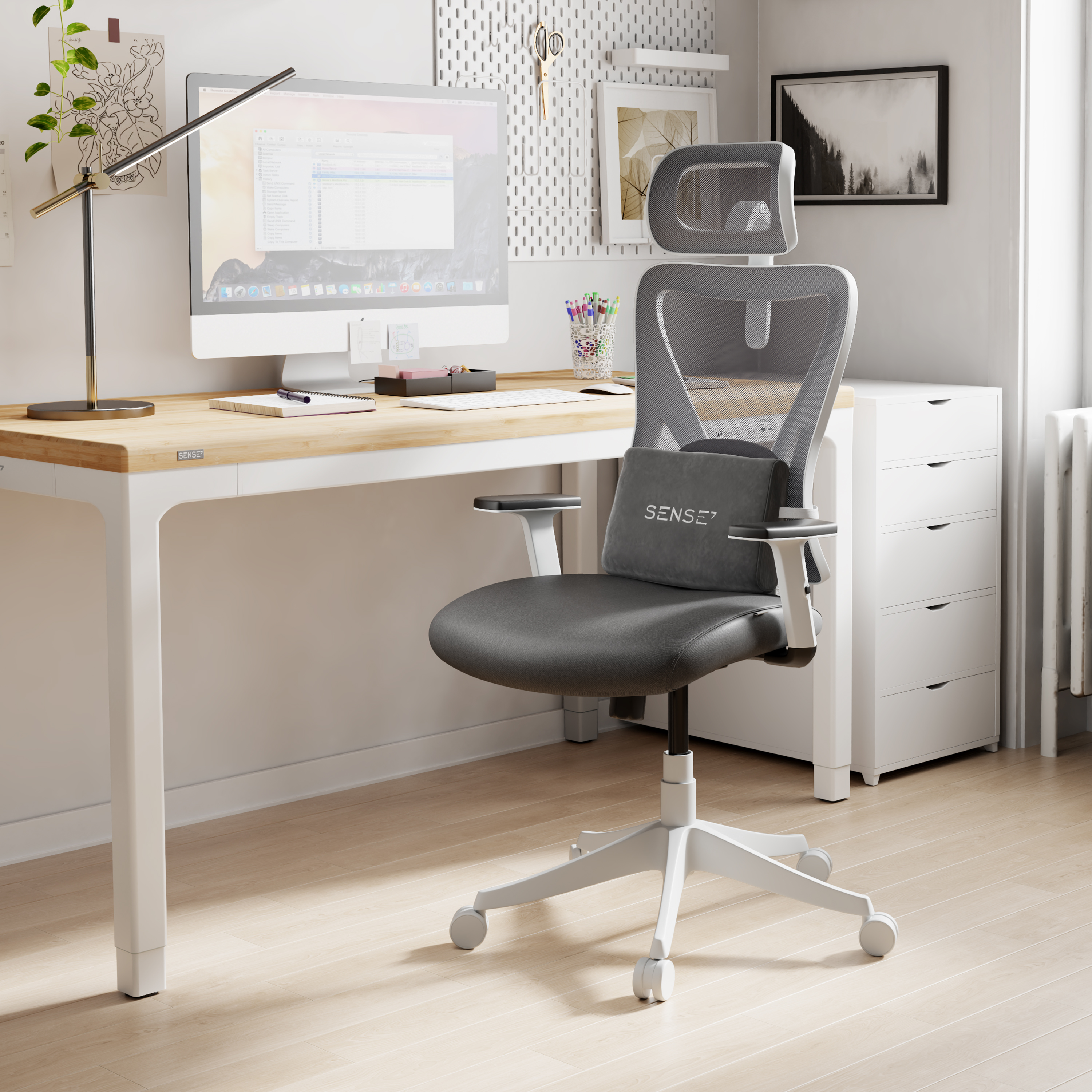 Ein Schreibtisch mit Computer, Stuhl und Lampe. Der Stuhl ist grau. Der Schreibtisch ist aus Holz.