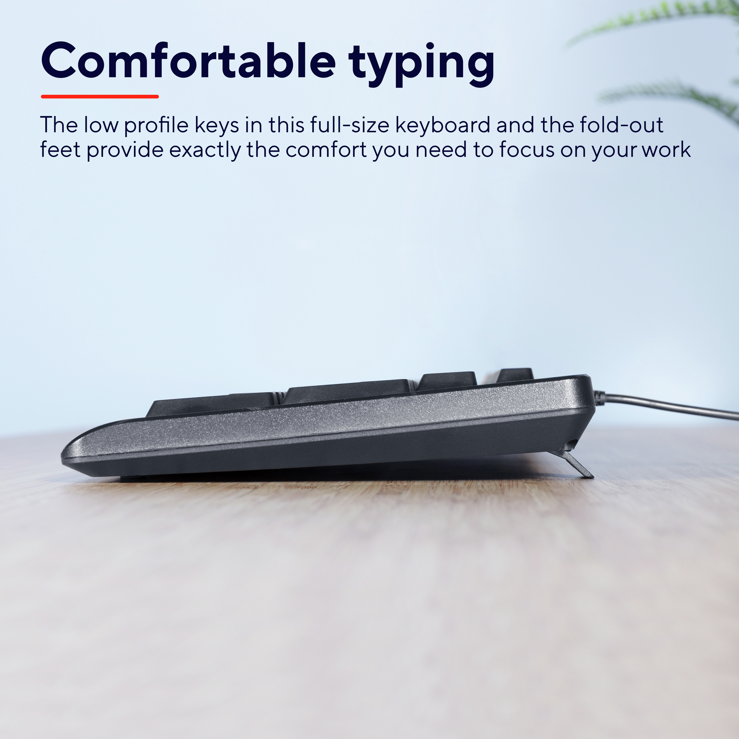 Seitenansicht einer schwarzen Tastatur auf einer Holzoberfläche. Die Tasten sind sichtbar.