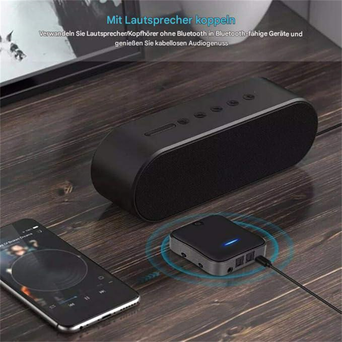Ein Lautsprecher und ein Bluetooth-Gerät, die mit einem Telefon auf einer Holzoberfläche verbunden sind.