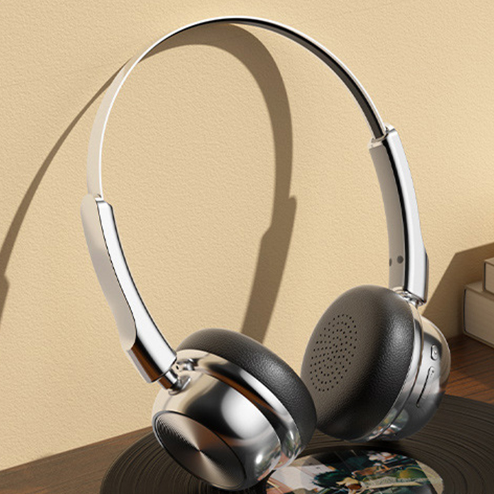Silberne und schwarze Kopfhörer auf einer Schallplatte. Die Kopfhörer sind Over-Ear-Stil.