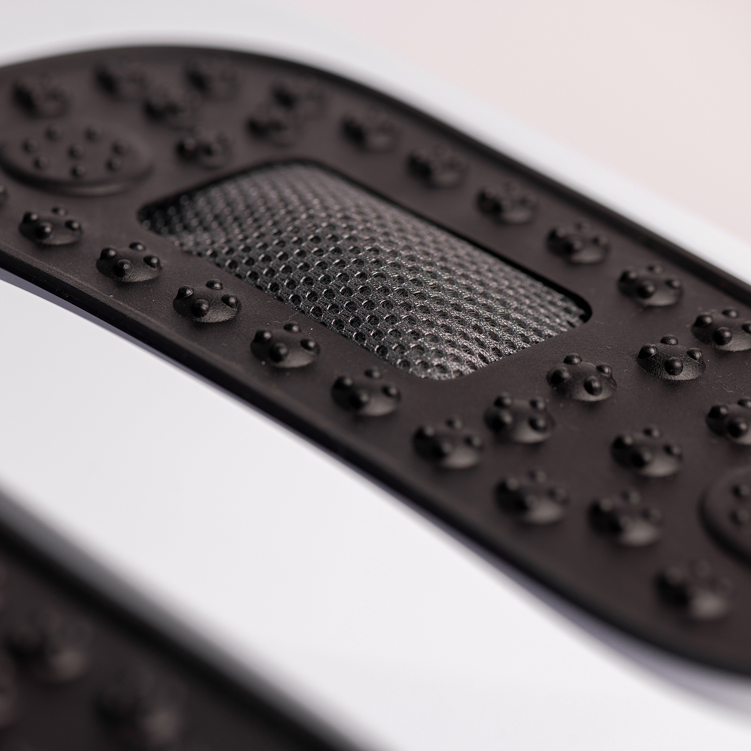 Black insole with textured surface, featuring small bumps and a mesh area.