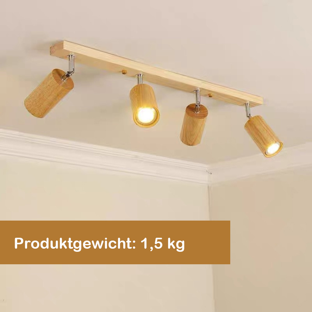 Holz-Schienenleuchte mit vier Strahlern an einer weißen Decke. Ein Strahler ist beleuchtet.