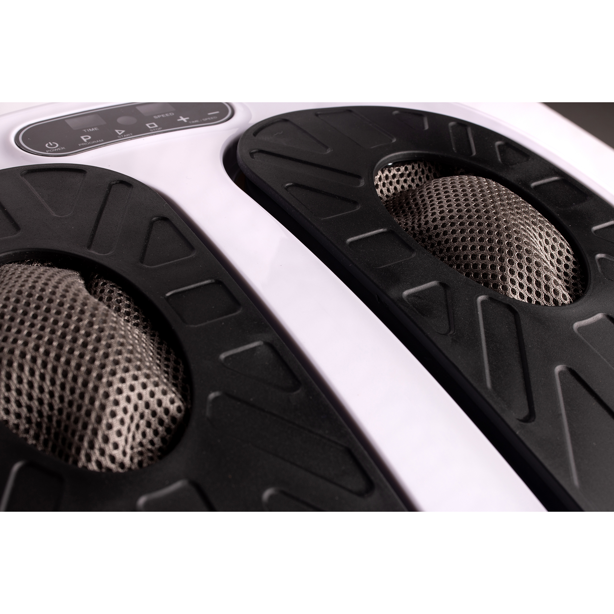 Close-up of a white foot massager with black footrests. Perforated pads are visible.