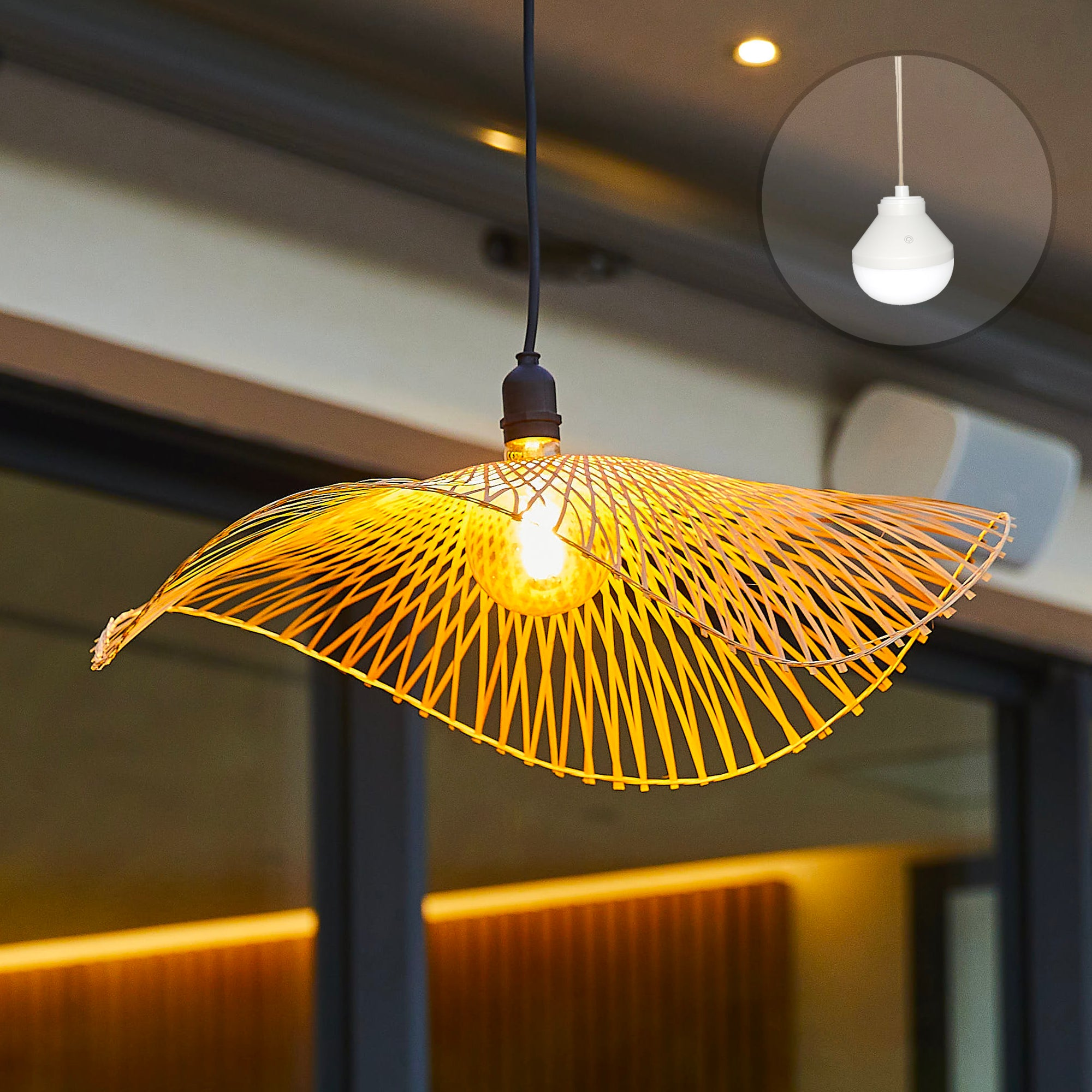 Eine gelbe Lampe mit bambusähnlichem Schirm hängt von der Decke, mit einem kleineren Einsatz einer ähnlichen Lampe.