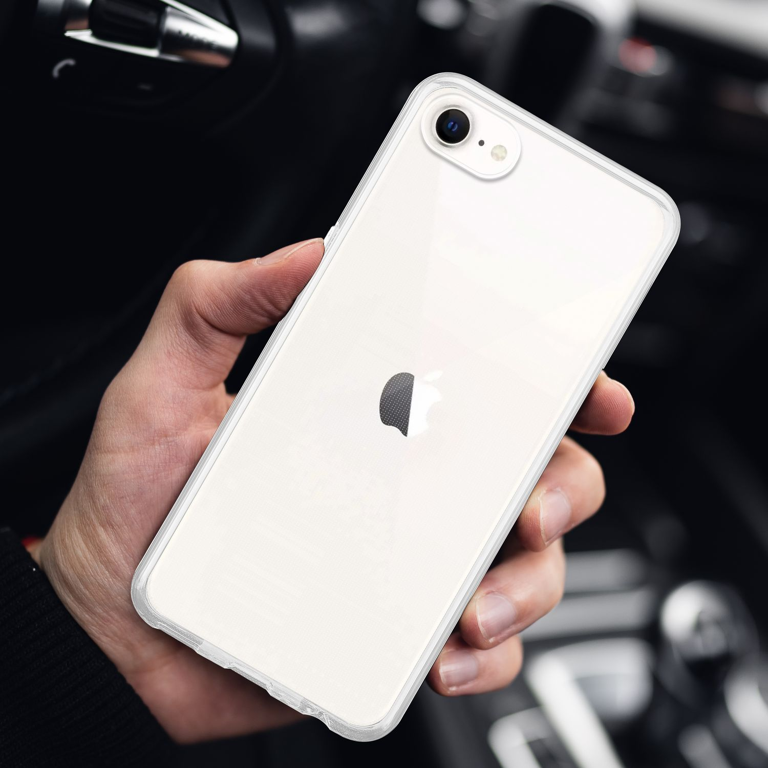 Eine Hand, die ein weißes Telefon mit einer durchsichtigen Hülle hält. Das Telefon hat ein schwarzes Apple-Logo.
