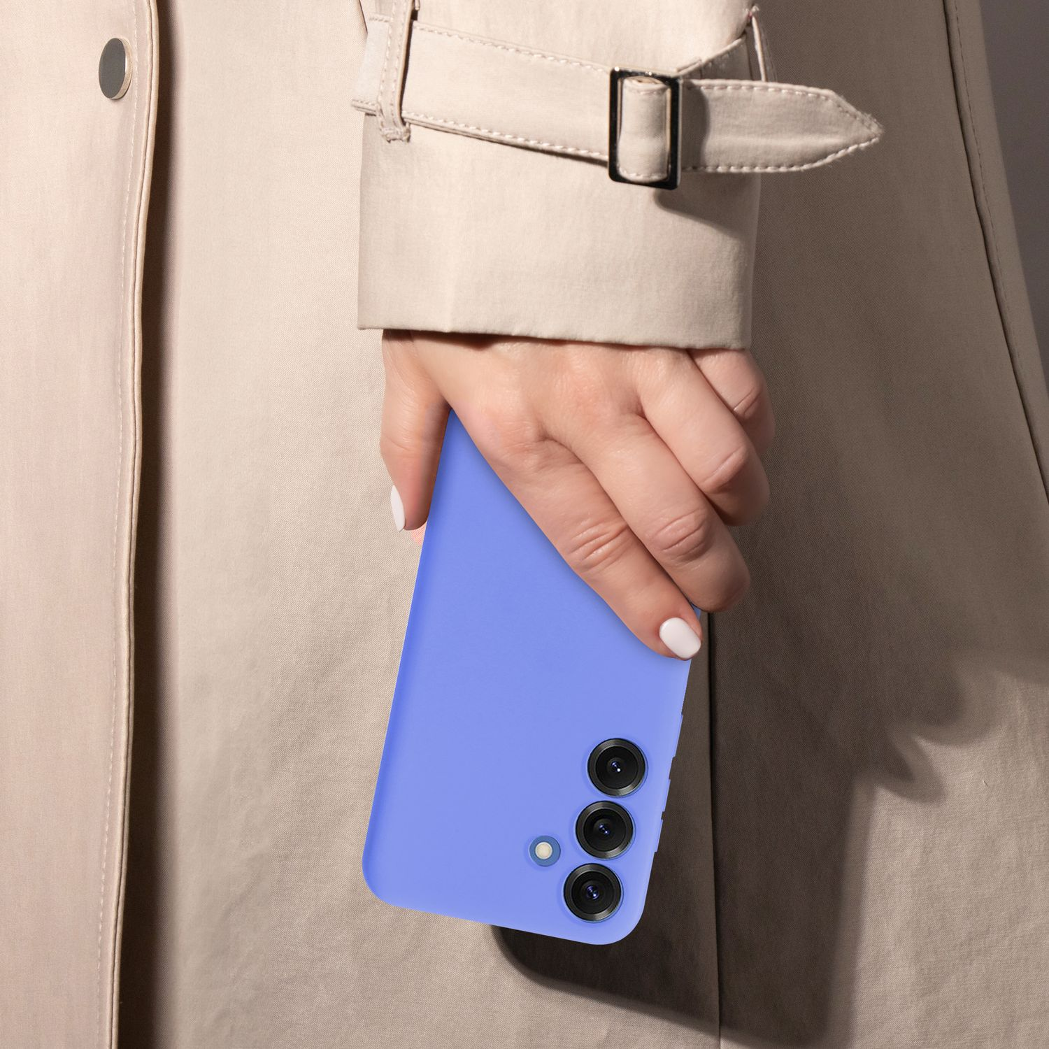 Eine Hand hält ein blaues Telefon, trägt einen hellen Mantel.