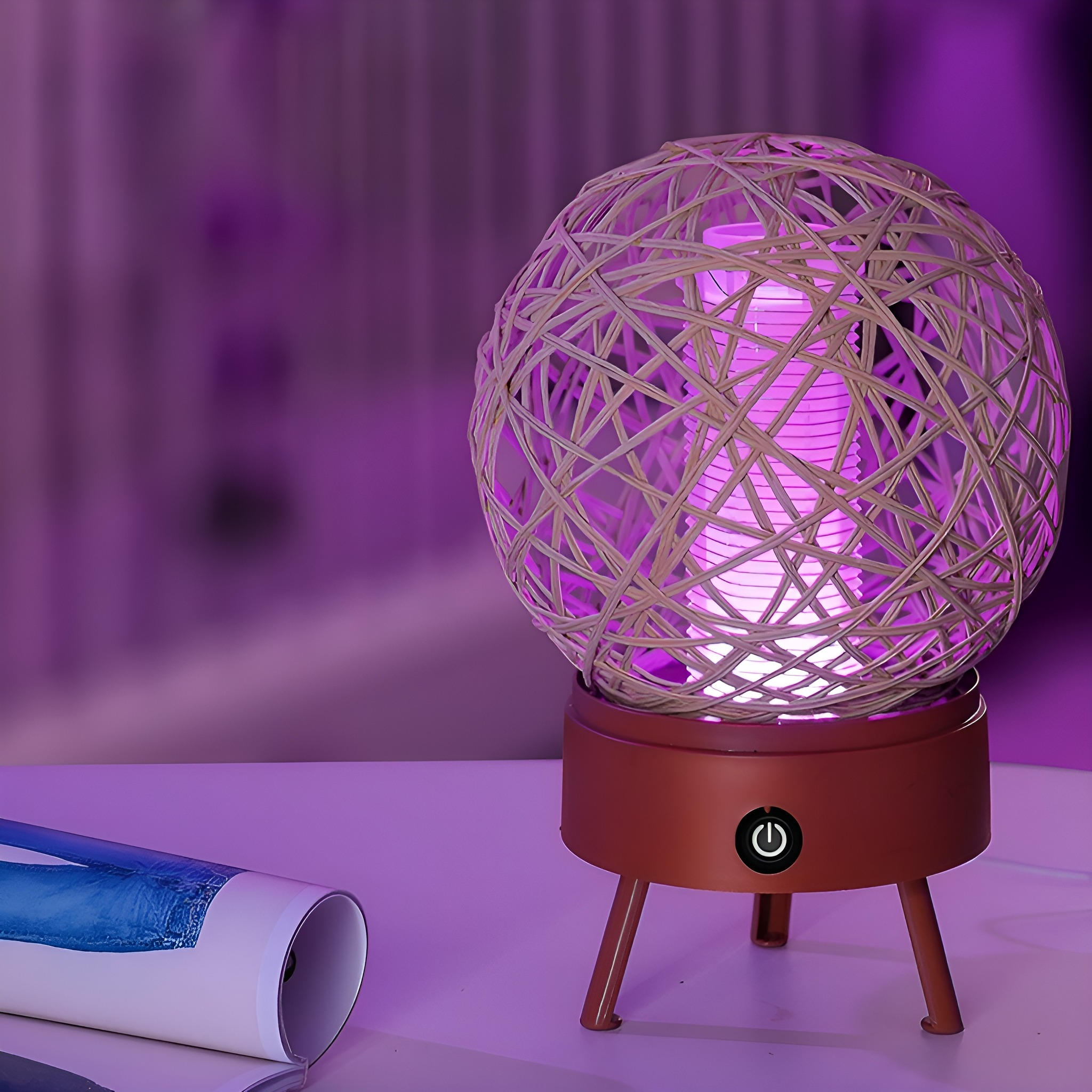 Runde gewebte Lampe mit braunem Sockel auf weißer Oberfläche, mit lila Hintergrund.