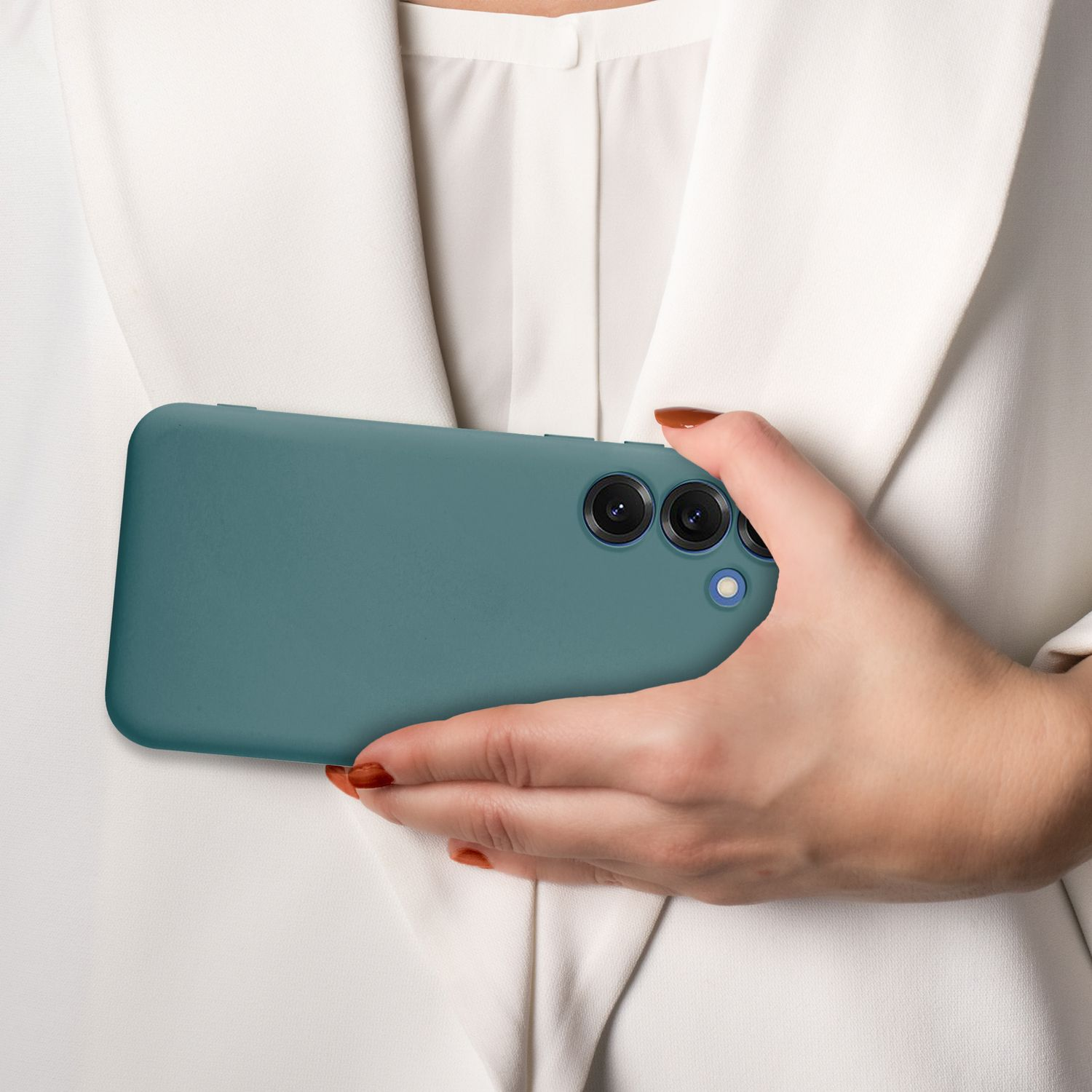 Hand einer Frau, die ein türkisfarbenes Telefon mit drei Kameras hält, vor weißem Hintergrund.