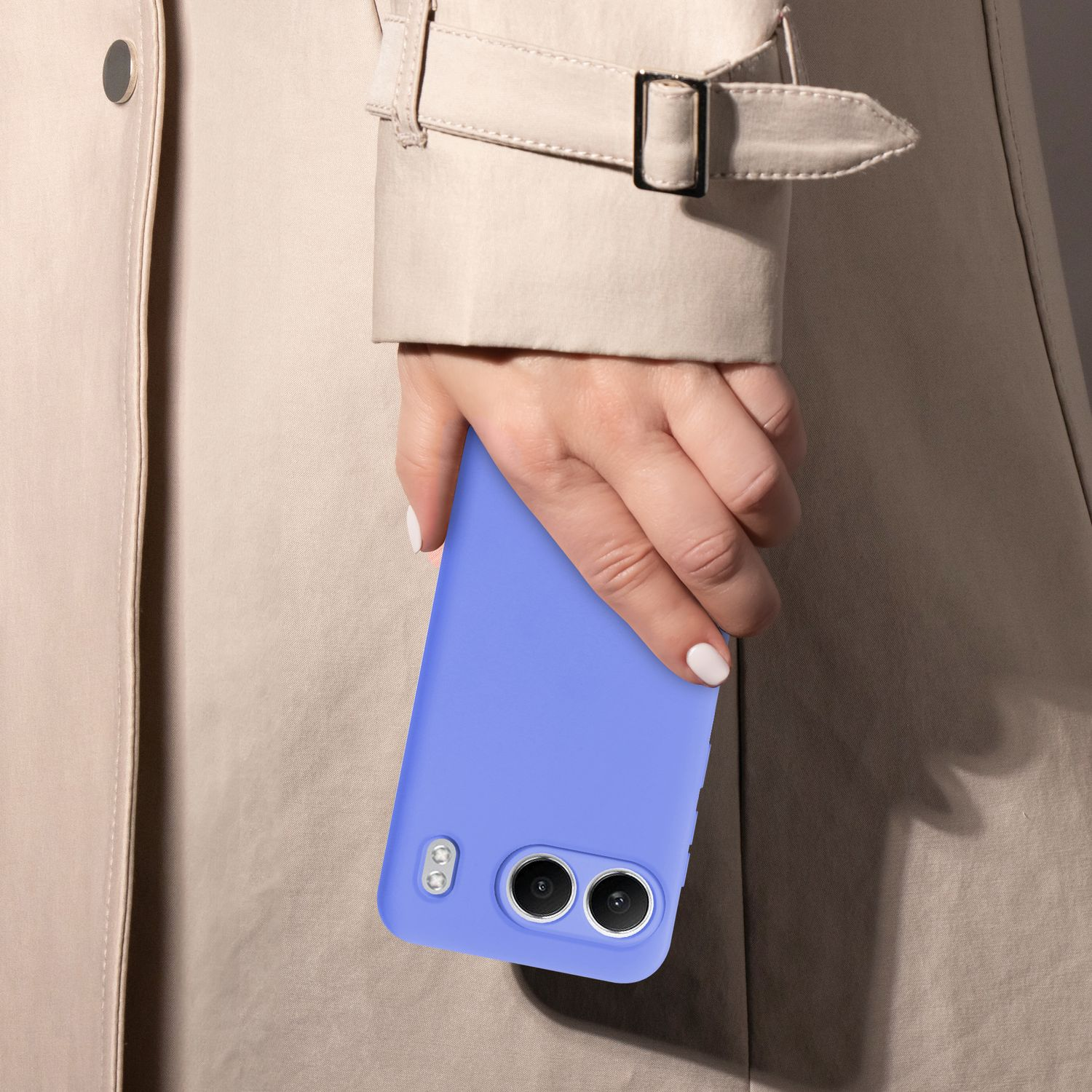 Frau hält eine blaue Handyhülle. Sie trägt einen beigen Trenchcoat und hat weißen Nagellack.