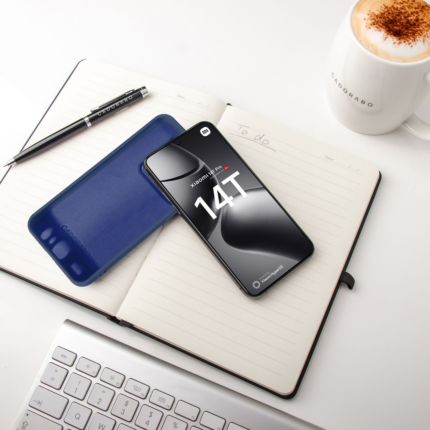 Telefon und Hülle auf einem Notizbuch mit Stift und einer Tasse Kaffee.