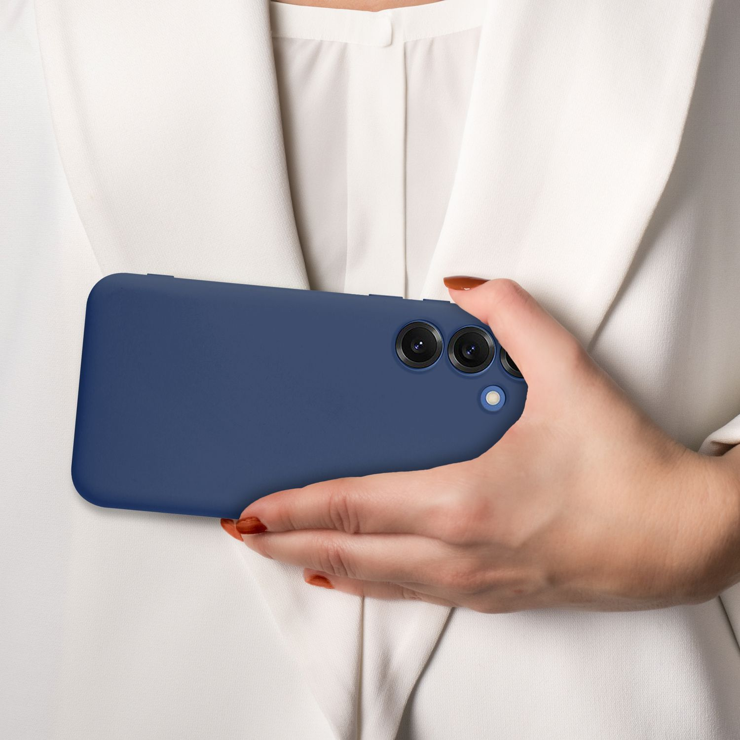 Eine Hand hält ein blaues Telefon, im Hintergrund eine weiße Bluse.