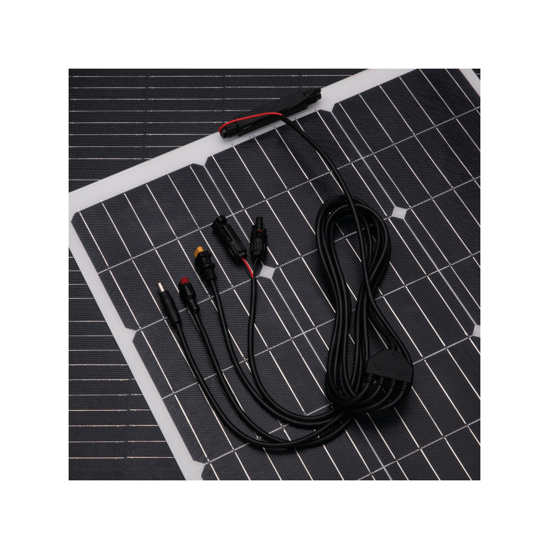 Panel słoneczny z czarnymi ogniwami i czarnym kablem z różnymi złączami. Białe tło.