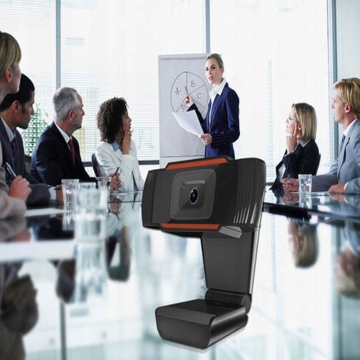 Kobieta prezentuje na spotkaniu z kolegami. Kamera internetowa na pierwszym planie.