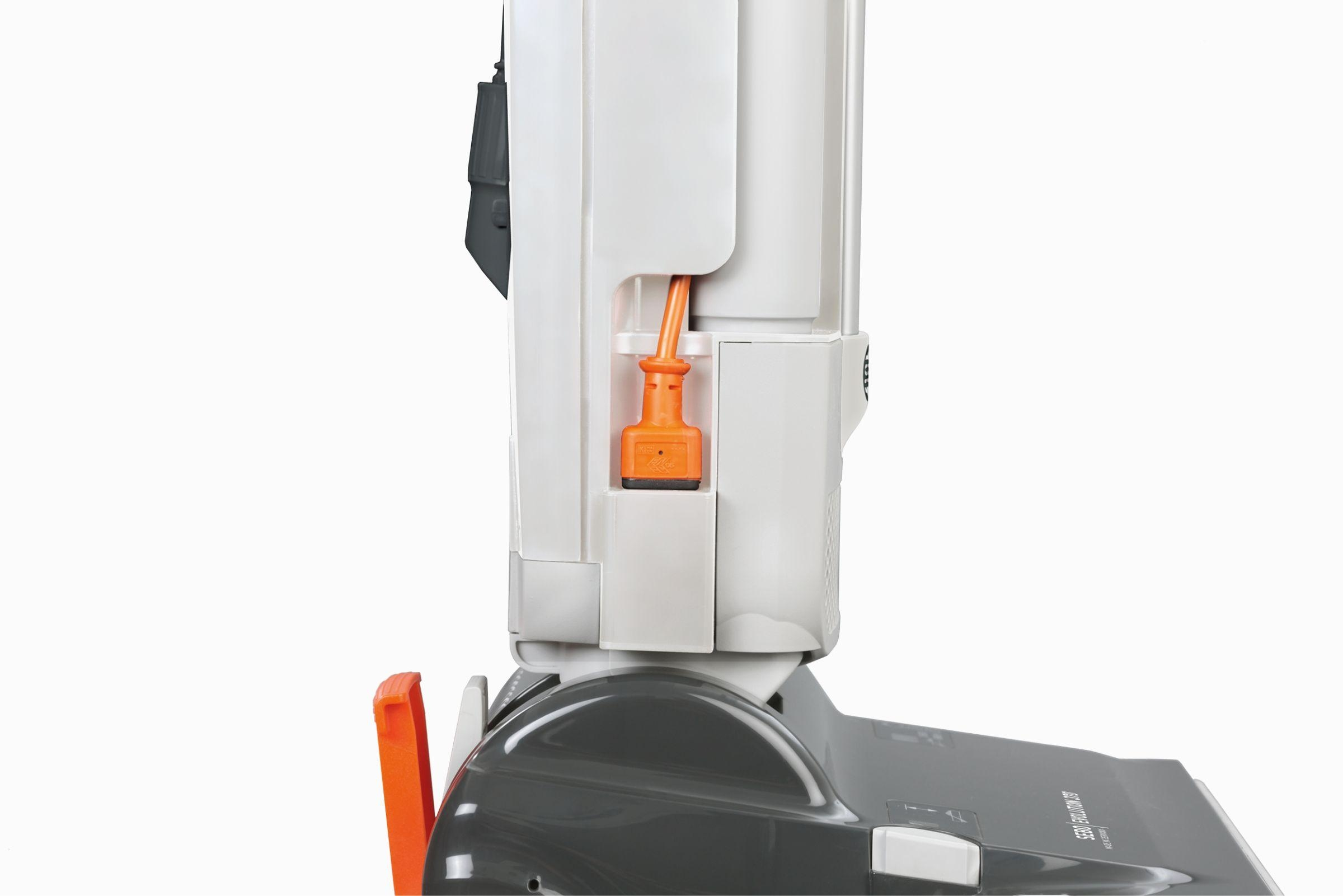 Nahaufnahme eines weiß-grauen Roboterstaubsaugers mit orangefarbenem Stecker. Der Hintergrund ist weiß.
