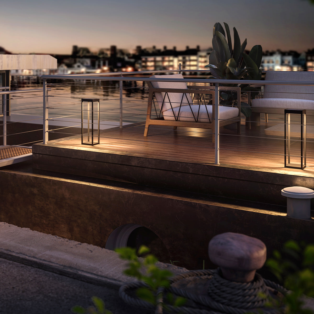 Außenszene bei Nacht mit Lichtern. Lichter auf einem Deck und eine Stadtansicht.