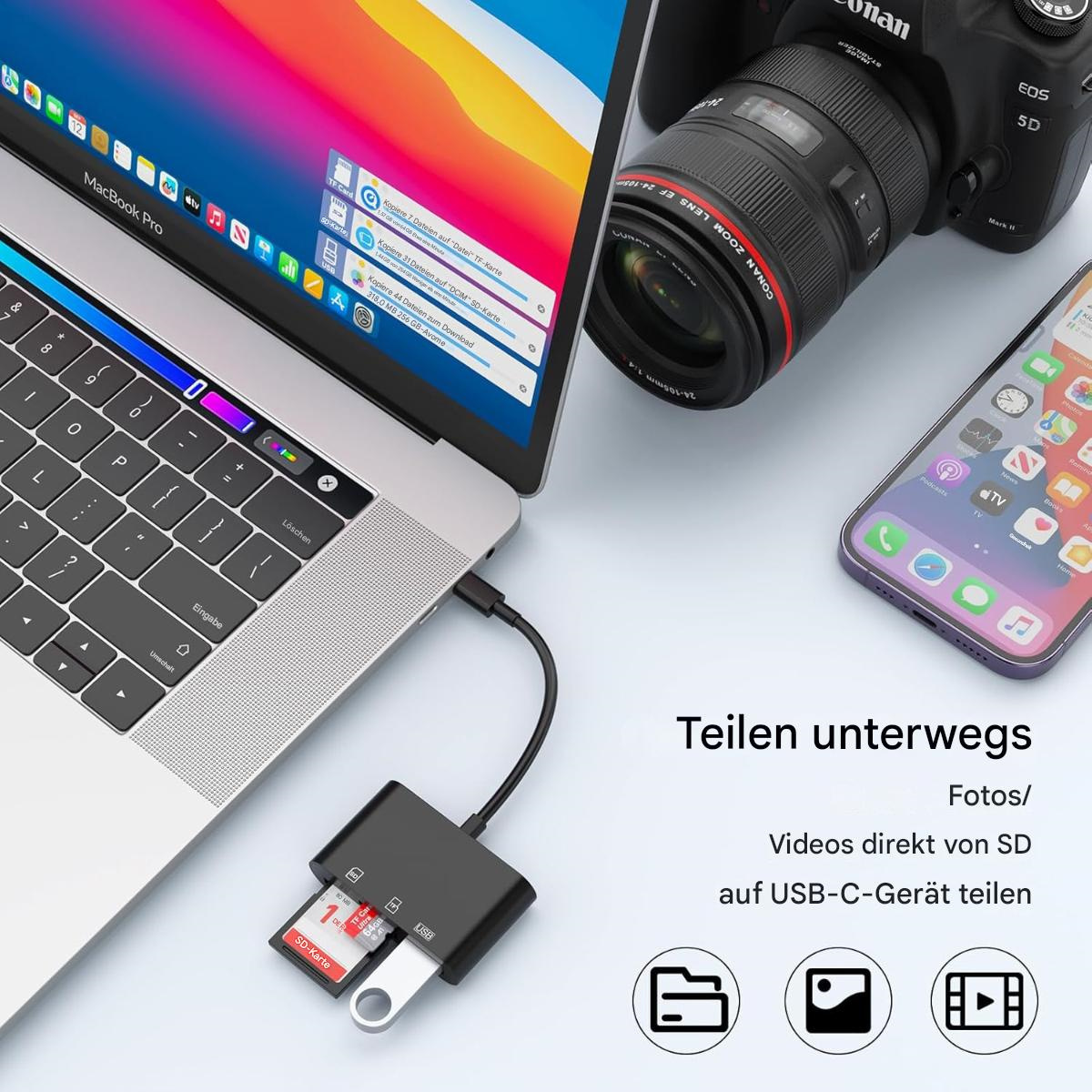 Ein Laptop mit USB-C-Adapter, Kamera und Telefon auf einem Tisch.