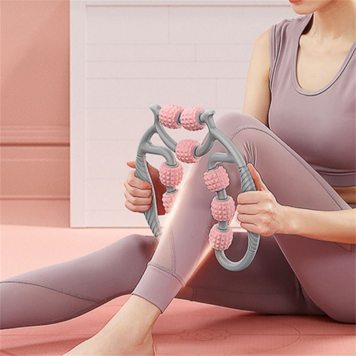Frau benutzt ein rosa Rollwerkzeug für ihr Bein. Trägt lila Leggings. Einfacher Hintergrund.