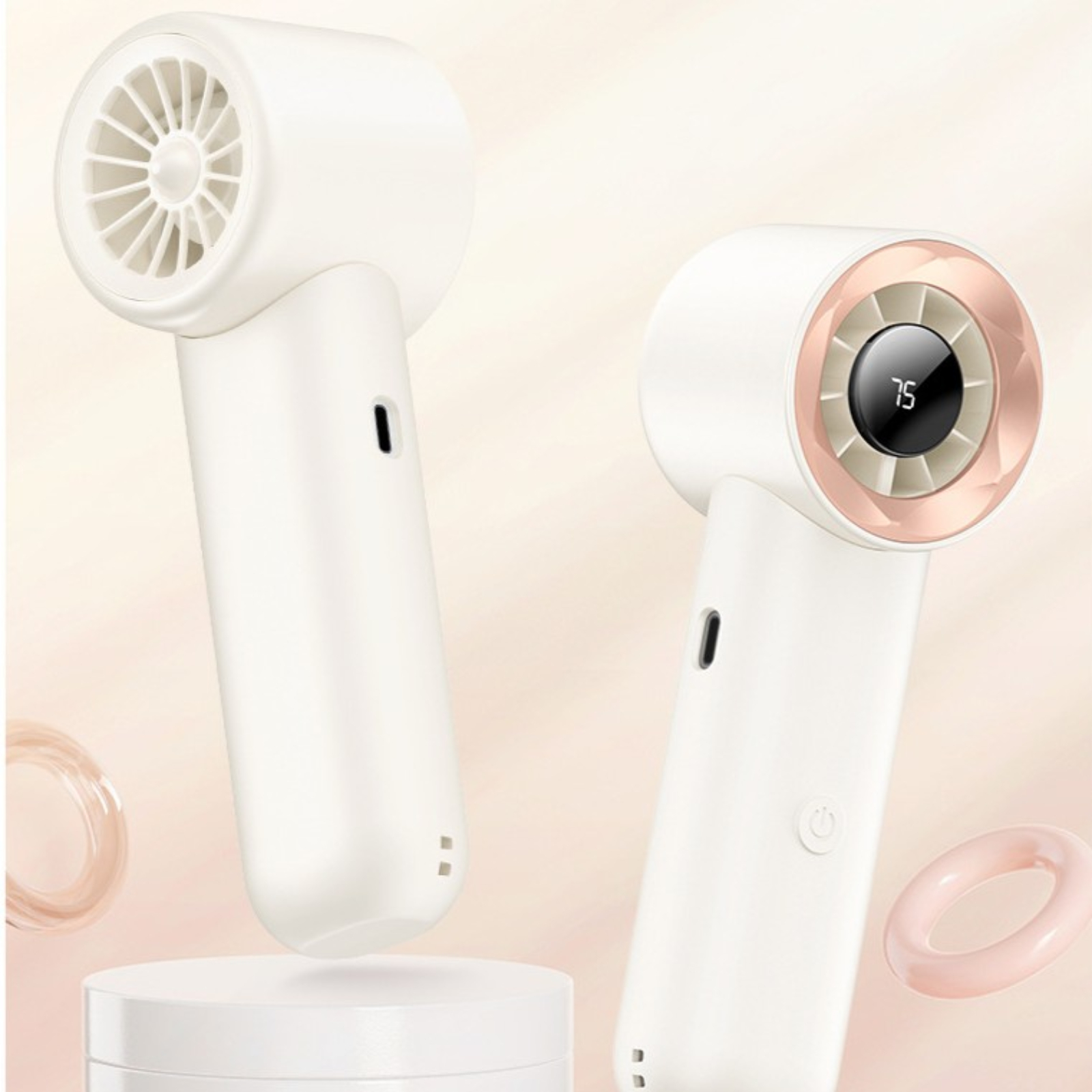 Zwei weiße und roségoldene Handventilatoren, die auf einer weißen Oberfläche ruhen.