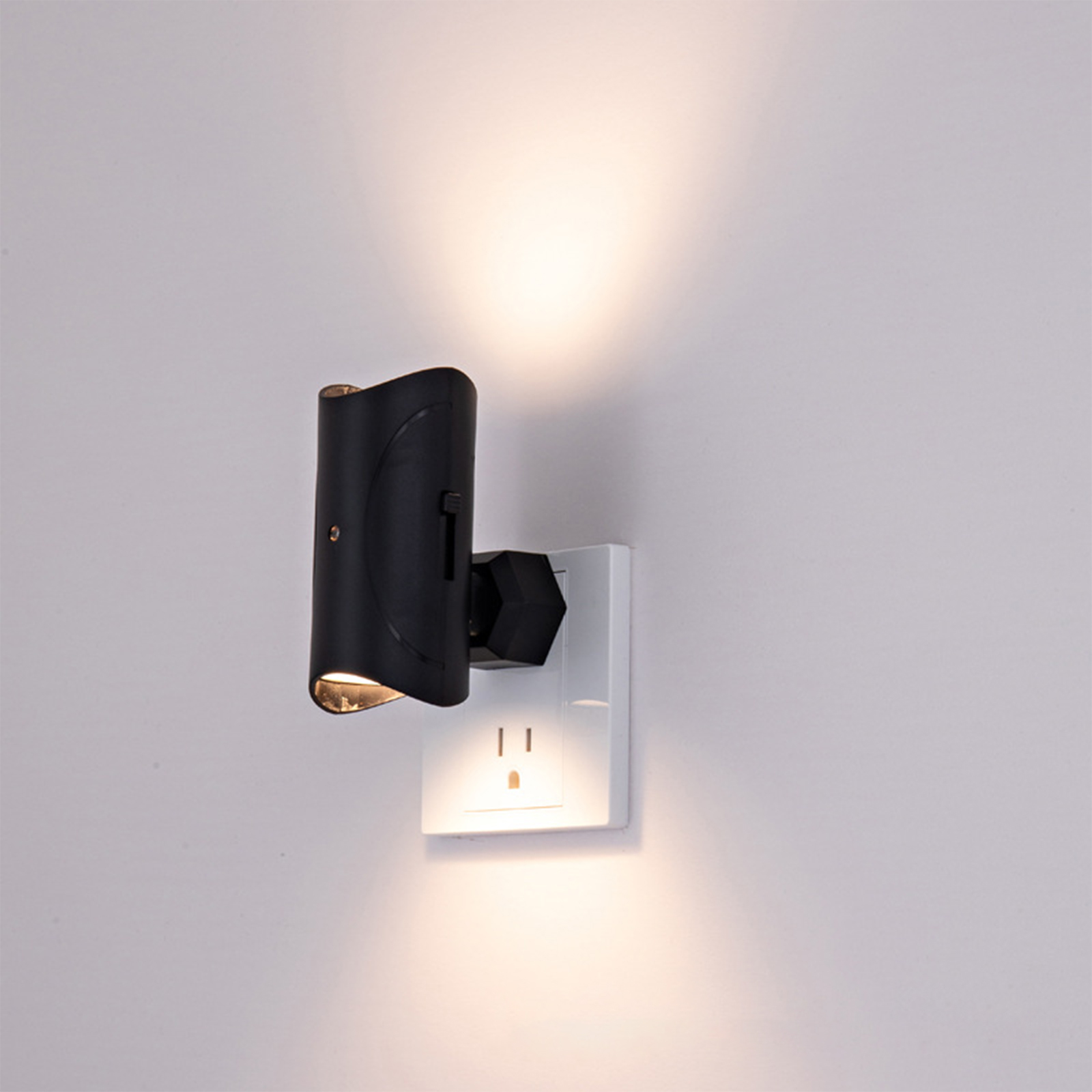 Eine schwarze, an der Wand montierte Leuchte, die in eine weiße Steckdose eingesteckt ist und Licht wirft.