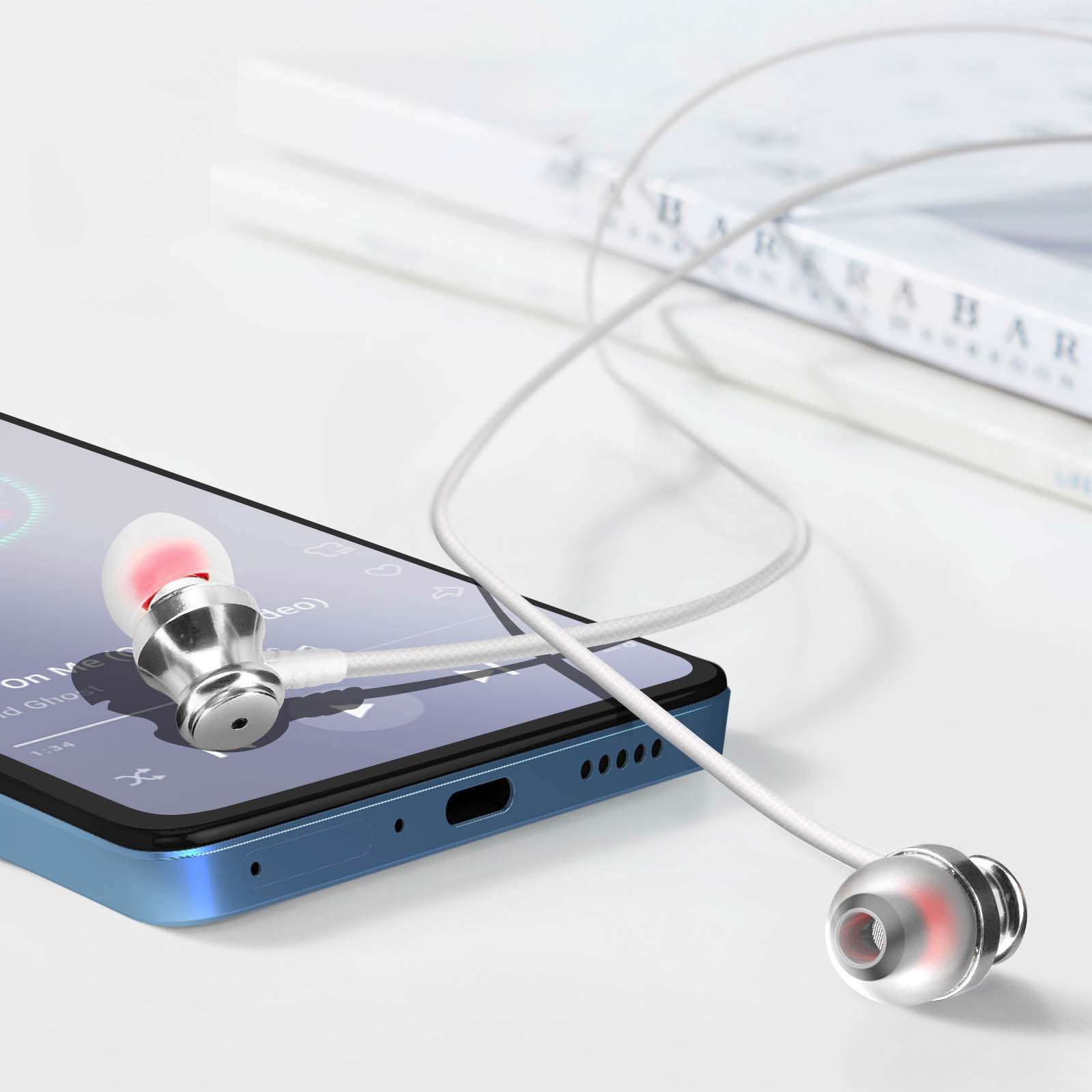 Auriculares con micrófono conectados a un teléfono. Cable blanco, carcasa de auricular plateada y roja. Fondo blanco.
