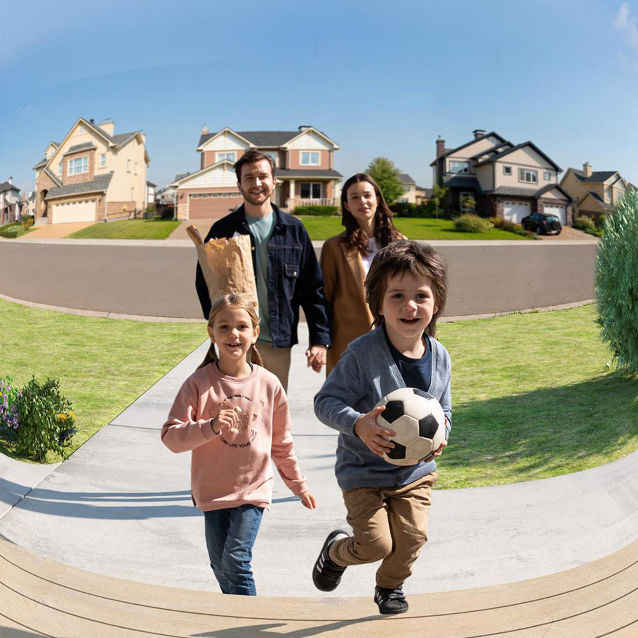 Familie geht einen Weg entlang. Zwei Kinder rennen voraus, eines mit einem Fußball. Häuser und blauer Himmel im Hintergrund.