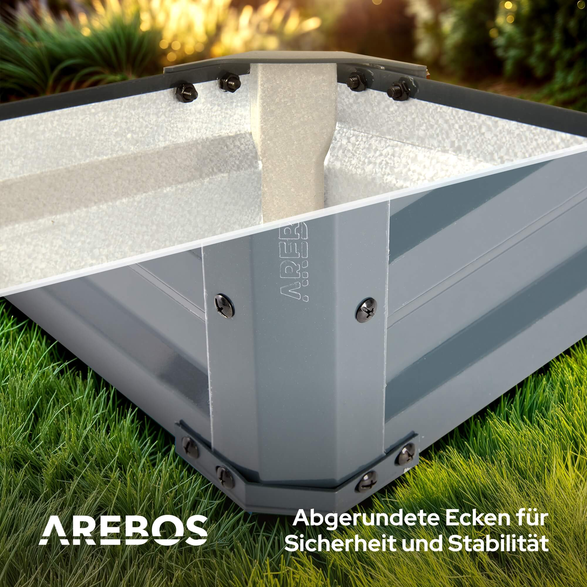 Ein graues, erhöhtes Hochbeet aus Metall in einem grasbewachsenen Bereich, mit abgerundeten Ecken.