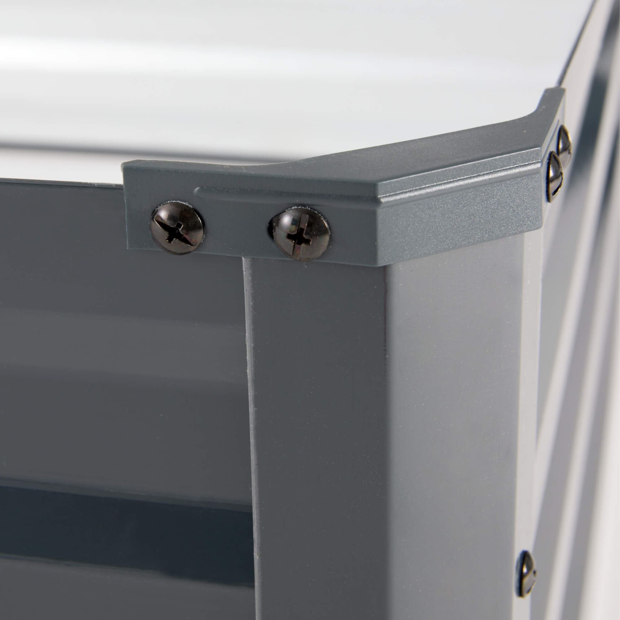 Nahaufnahme einer grauen Metallecke. Schrauben sind sichtbar. Weißer Hintergrund.