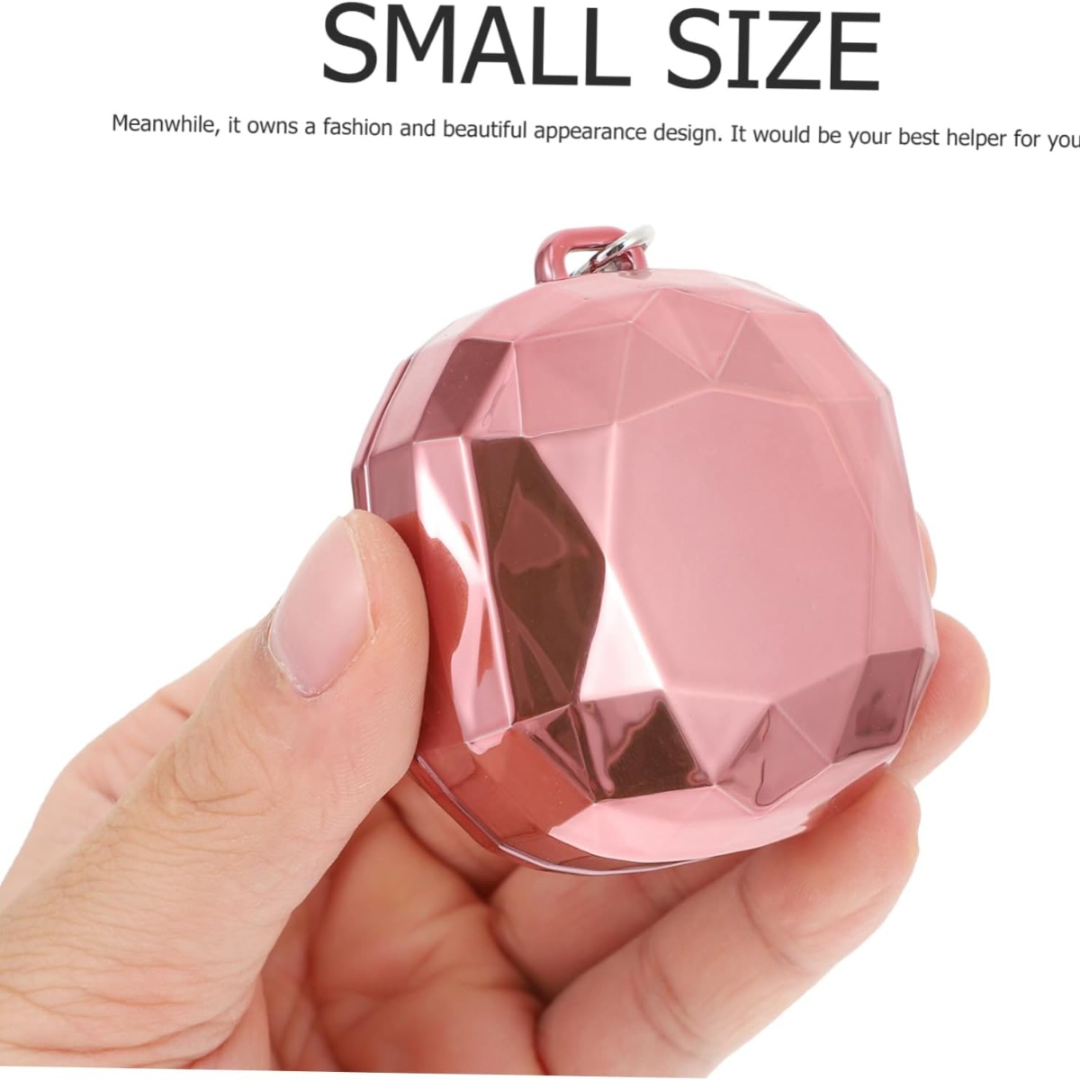 Ein kleines, rosa, geometrisch geformtes Objekt wird in einer Hand gehalten. Es ist ein Modeartikel.