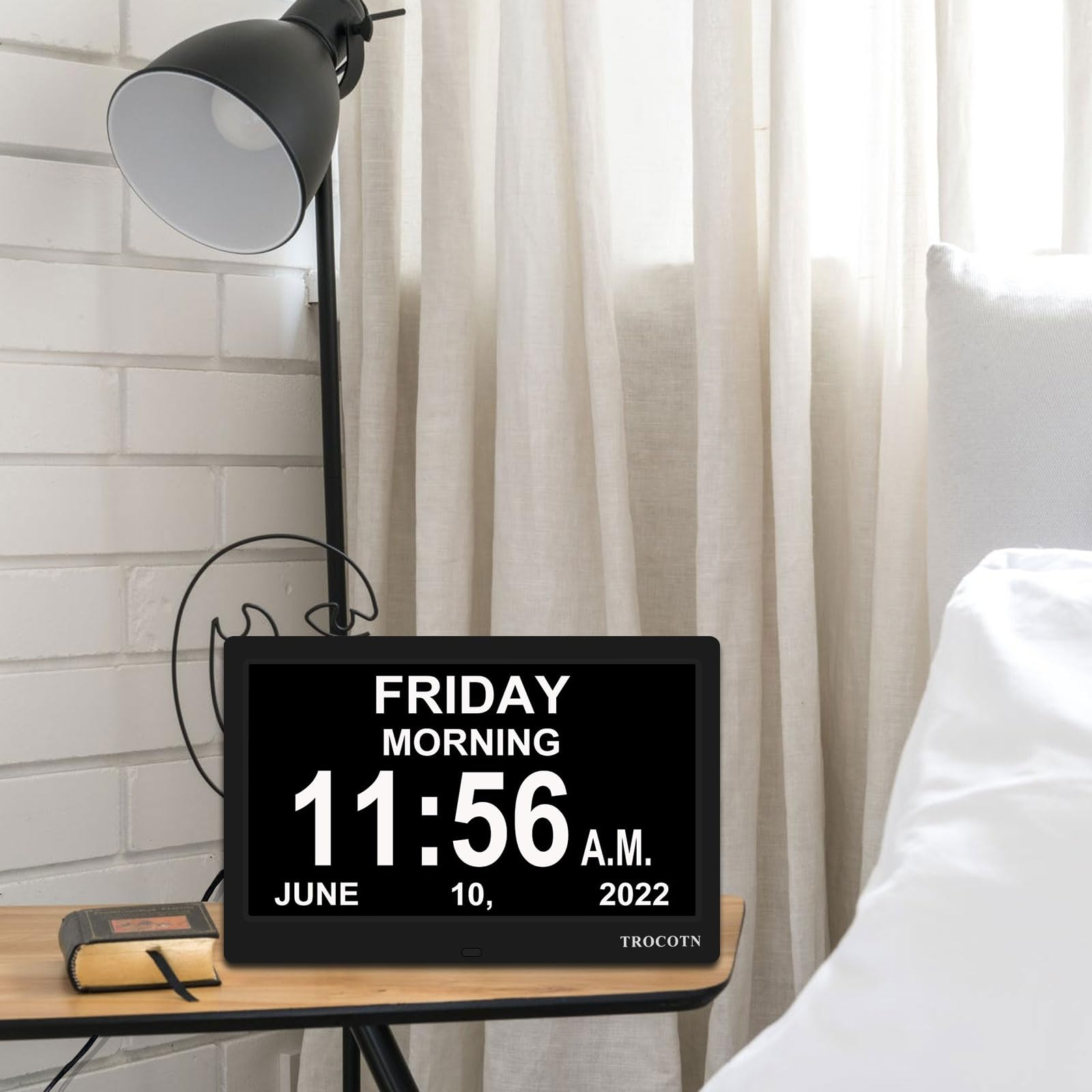 Uhr zeigt Freitag, Morgen, 11:56 Uhr, 10. Juni 2022. Lampe und Buch auf Nachttisch.