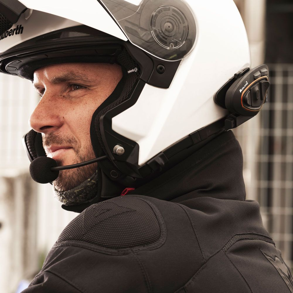 Mężczyzna w białym kasku z systemem komunikacji, patrzący w bok.