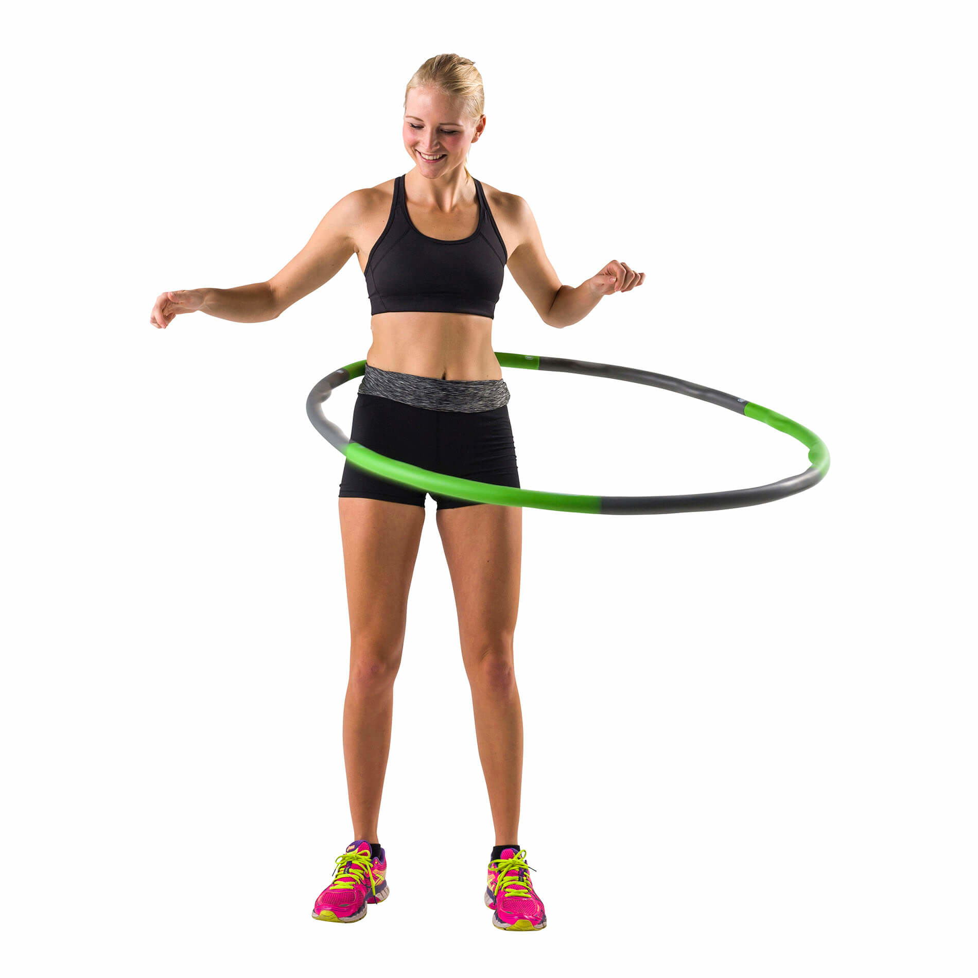 Femme faisant du hula hoop, souriante, vêtue de vêtements de sport, sur fond blanc.
