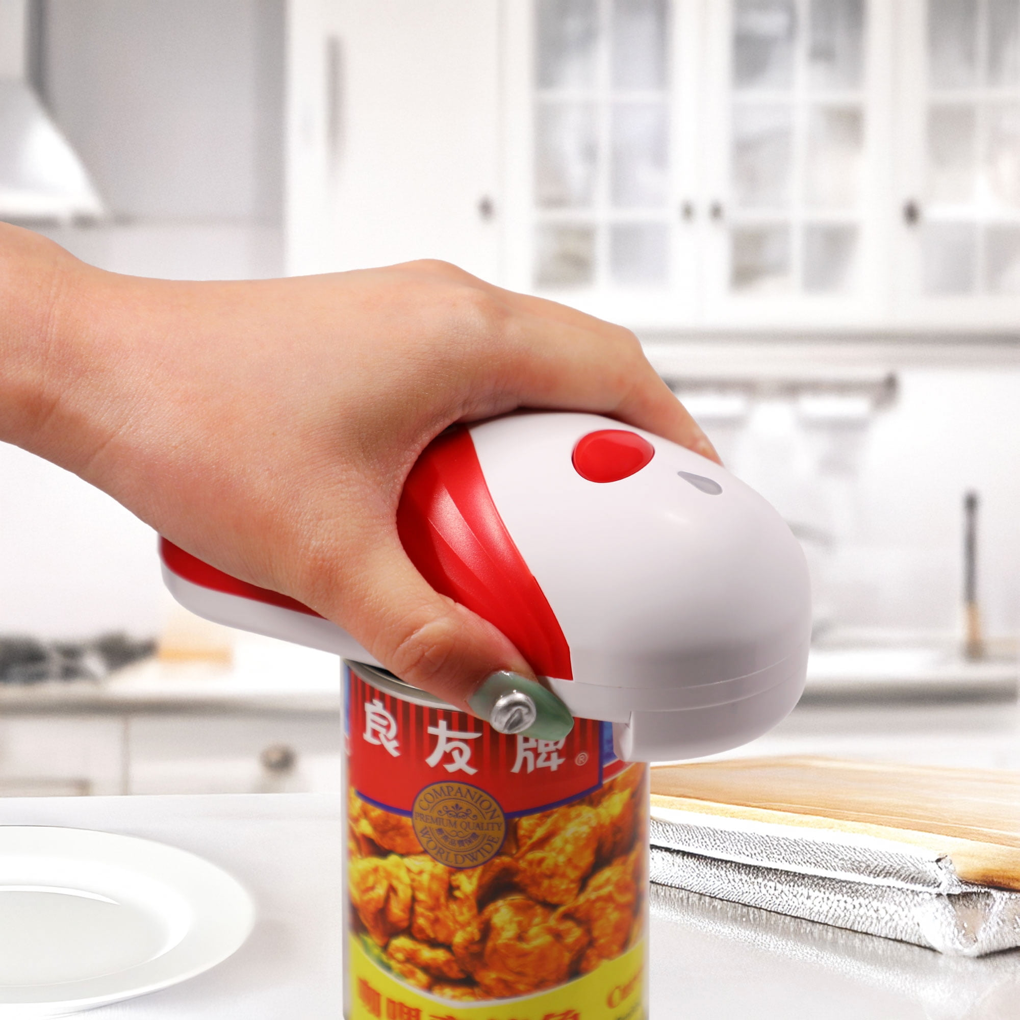 Eine Hand bedient einen rot-weißen elektrischen Dosenöffner auf einer Dose.